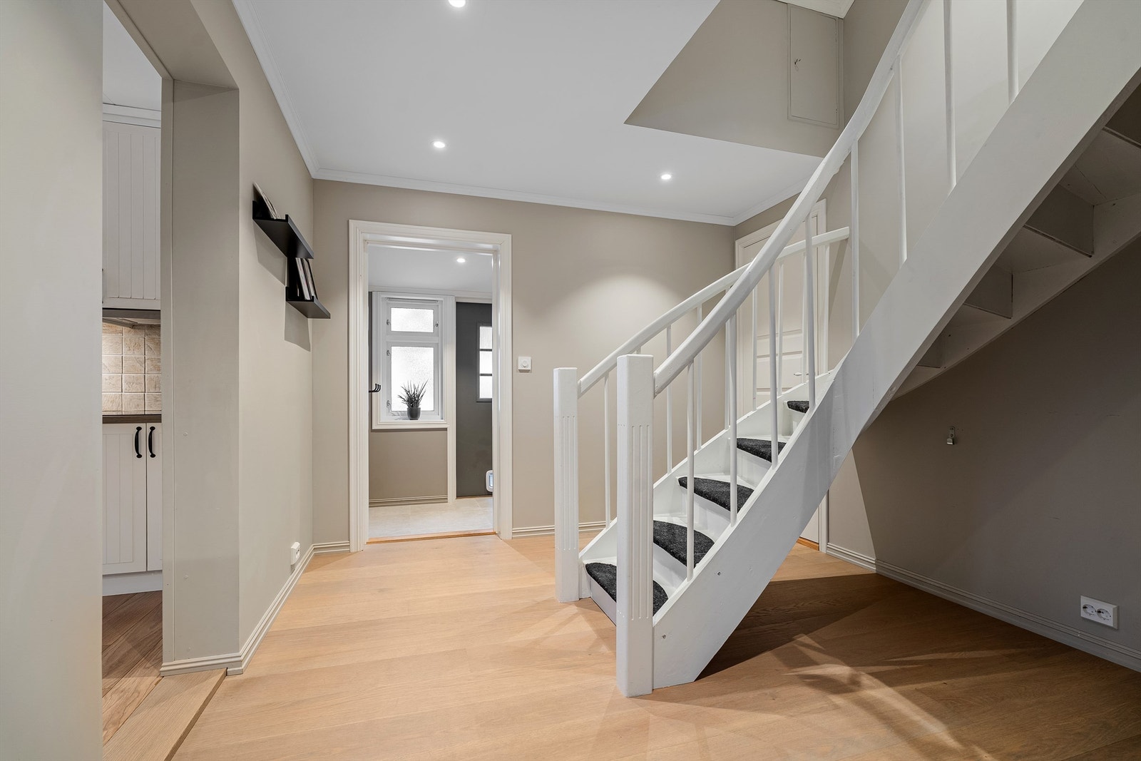 Lys og ryddig gang med trappeløsning som gir god flyt mellom etasjene og plass til barnevogn under trapp? Galleribilde