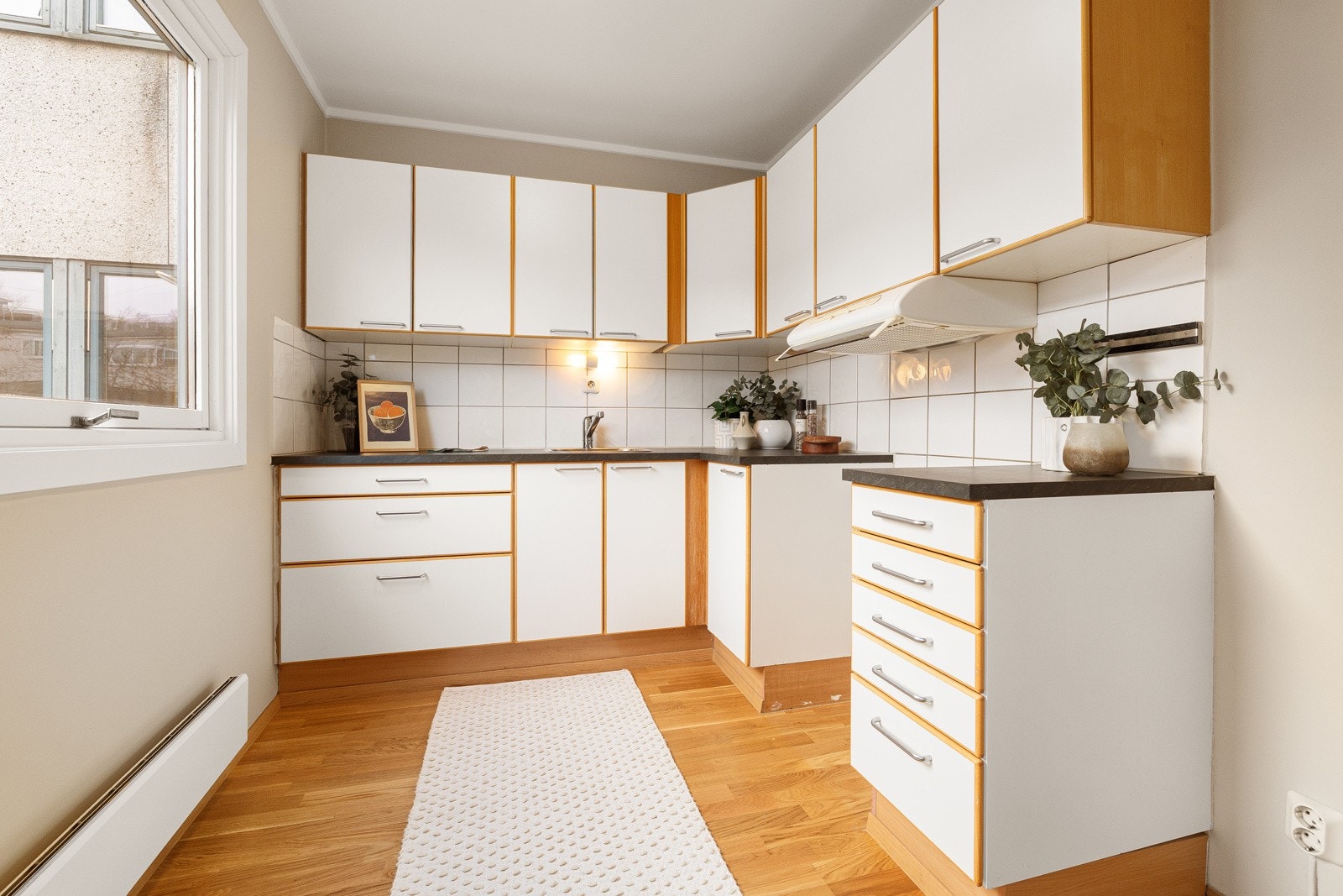 Separat eldre kjøkken med glatte fronter, laminert benkeplate med oppvaskkum i rustfritt stål med svingbart blandebatteri Galleribilde