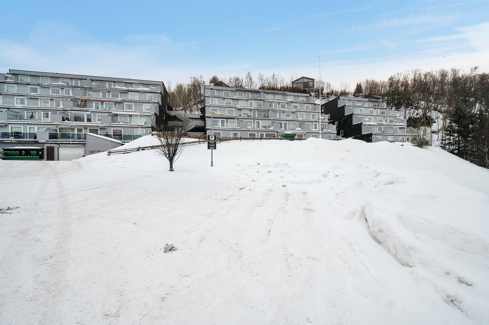 Gjesteparkering i front av fasade, det er trappeadkomst opp til leiligheten. Galleribilde