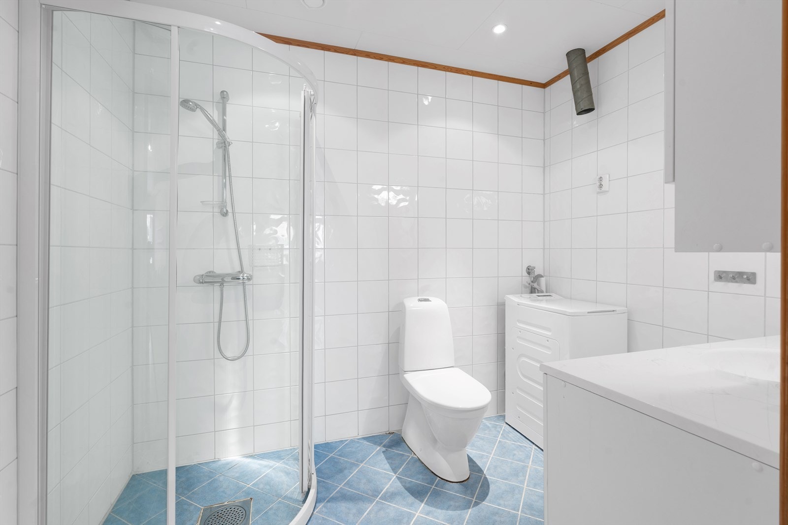 Komplett flislagt bad med praktiske innredninger og opplegg for vaskemaskin. Galleribilde