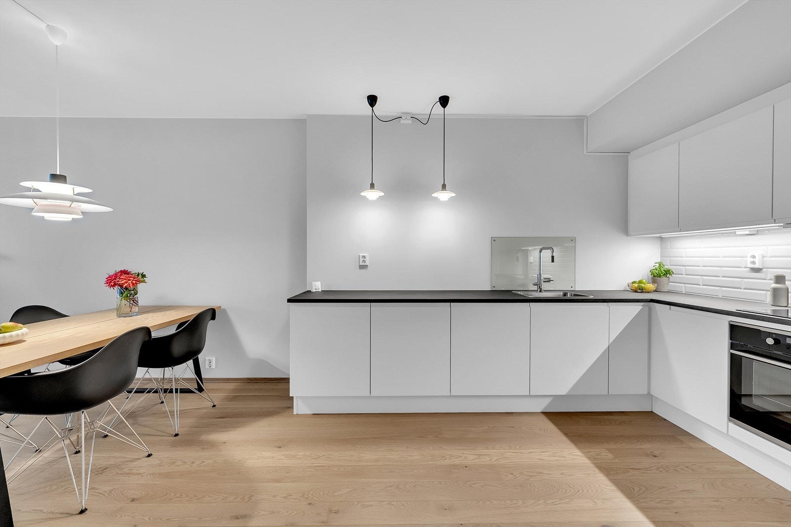 Lyst og moderne kjøkken innredet kjøkkenkum og integrert komfyr, koketopp, kjøleskap og oppvaskmaskin. Komfyrvakt. Kjøkkenventilator er montert over komfyr. Galleribilde