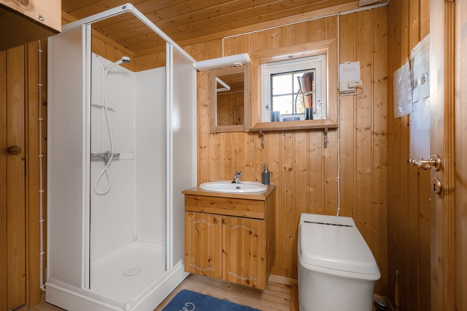 Funksjonelt innredet baderom med dusjløsning og Cinderella toalett. Galleribilde