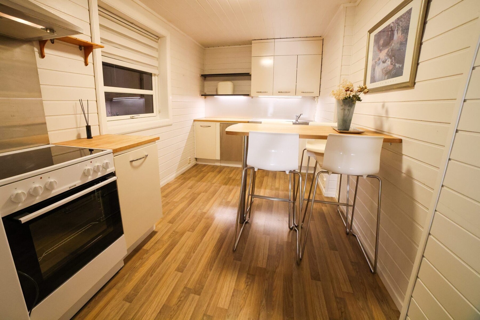 Kjøkkenet ligger i eget rom, og har malte fronter på innredningen. Det er rustfri oppvaskbenk og kummer, og det er både heltre- og laminatbenkeplater. Galleribilde