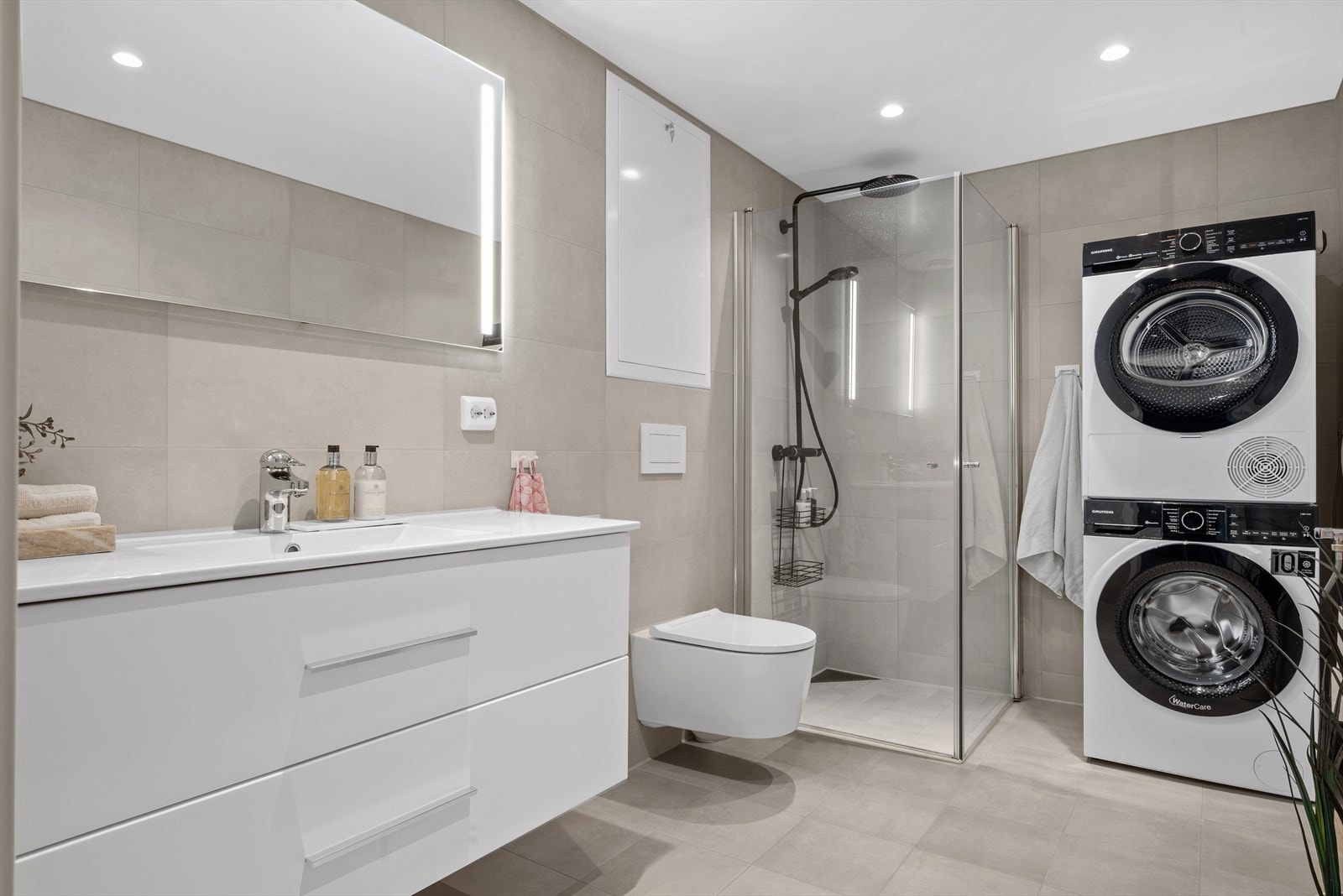 Badet er utstyrt med innfellbare dusjdører, servantskap, opplegg for vaskemaskin, rørfordelingsskap og mekanisk avtrekk. Galleribilde