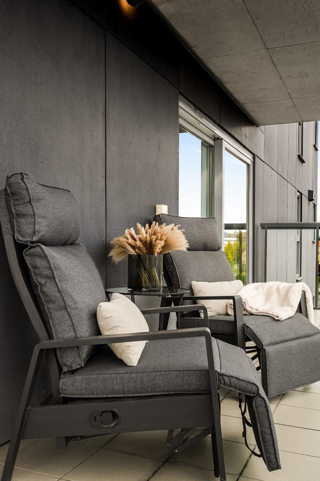 Balkongen har flislagt gulv og rekkverk av metall og glassfelt. Galleribilde