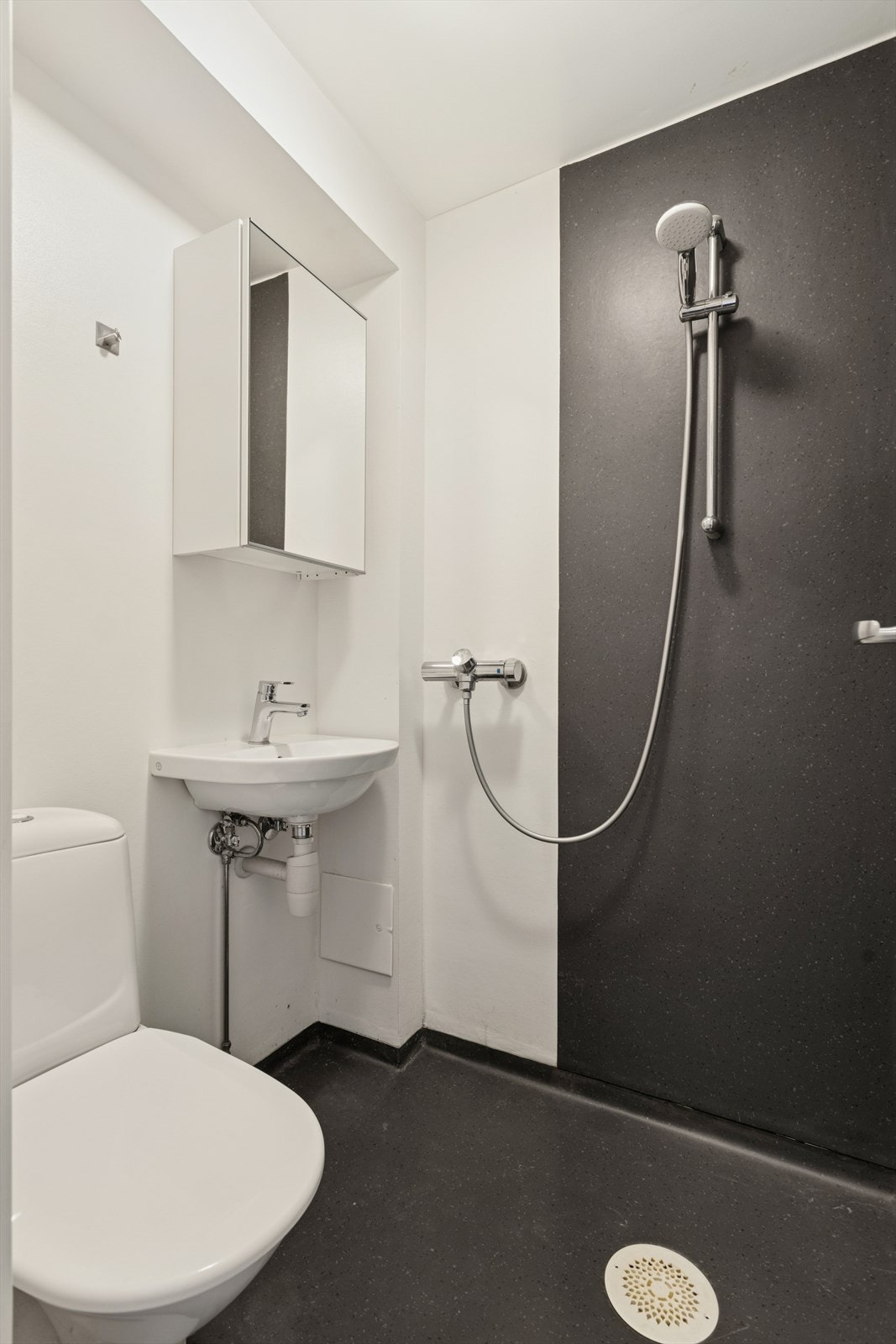 Badet ble oppusset i 2021 og byr på dusj, gulvvarme, servant med tilhørende speilskap og toalett. Galleribilde