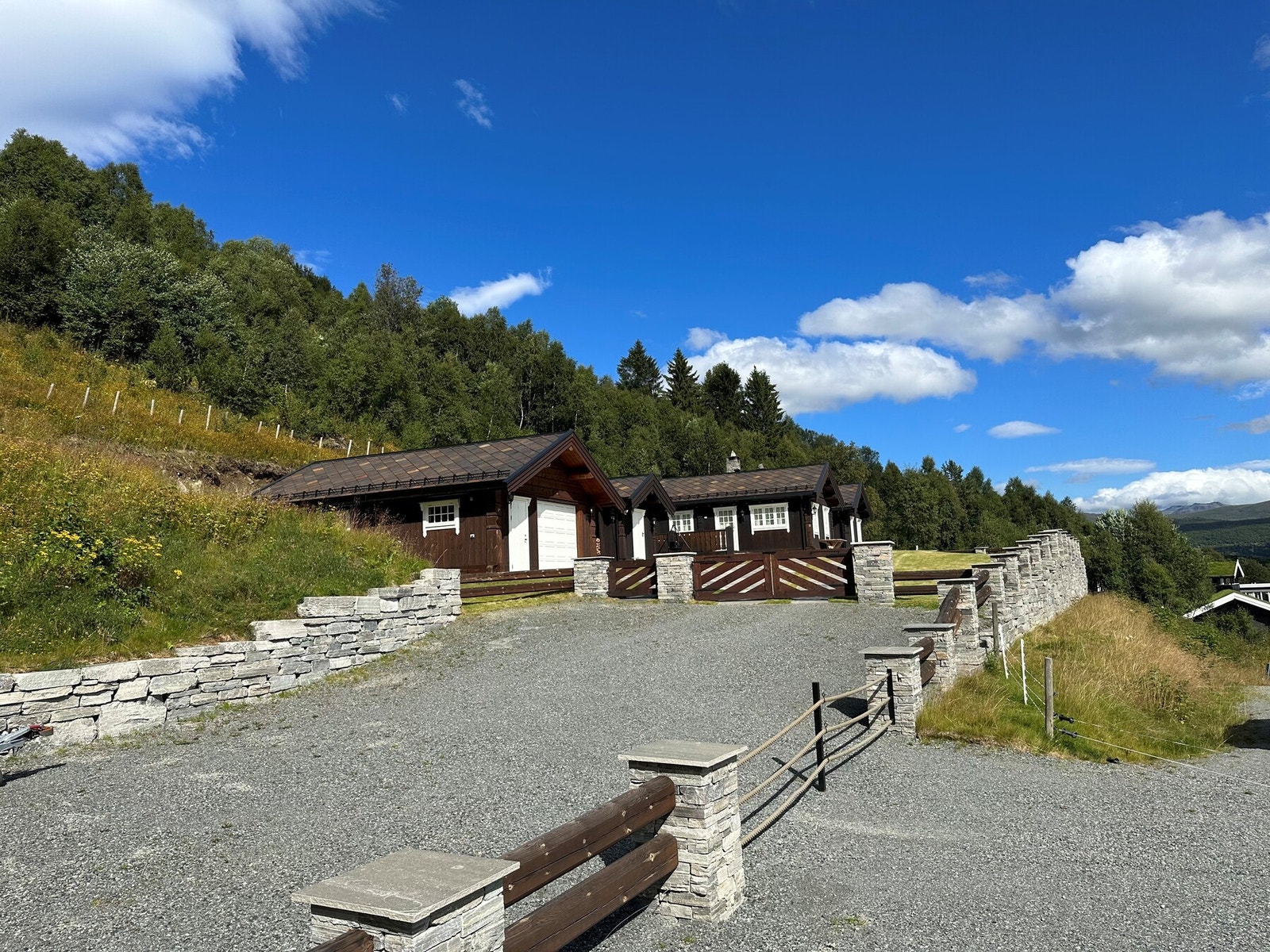 Det er lagt mye i å skape et vakkert og praktisk uteområde med råkoppsøyler og mur i naturstein Galleribilde