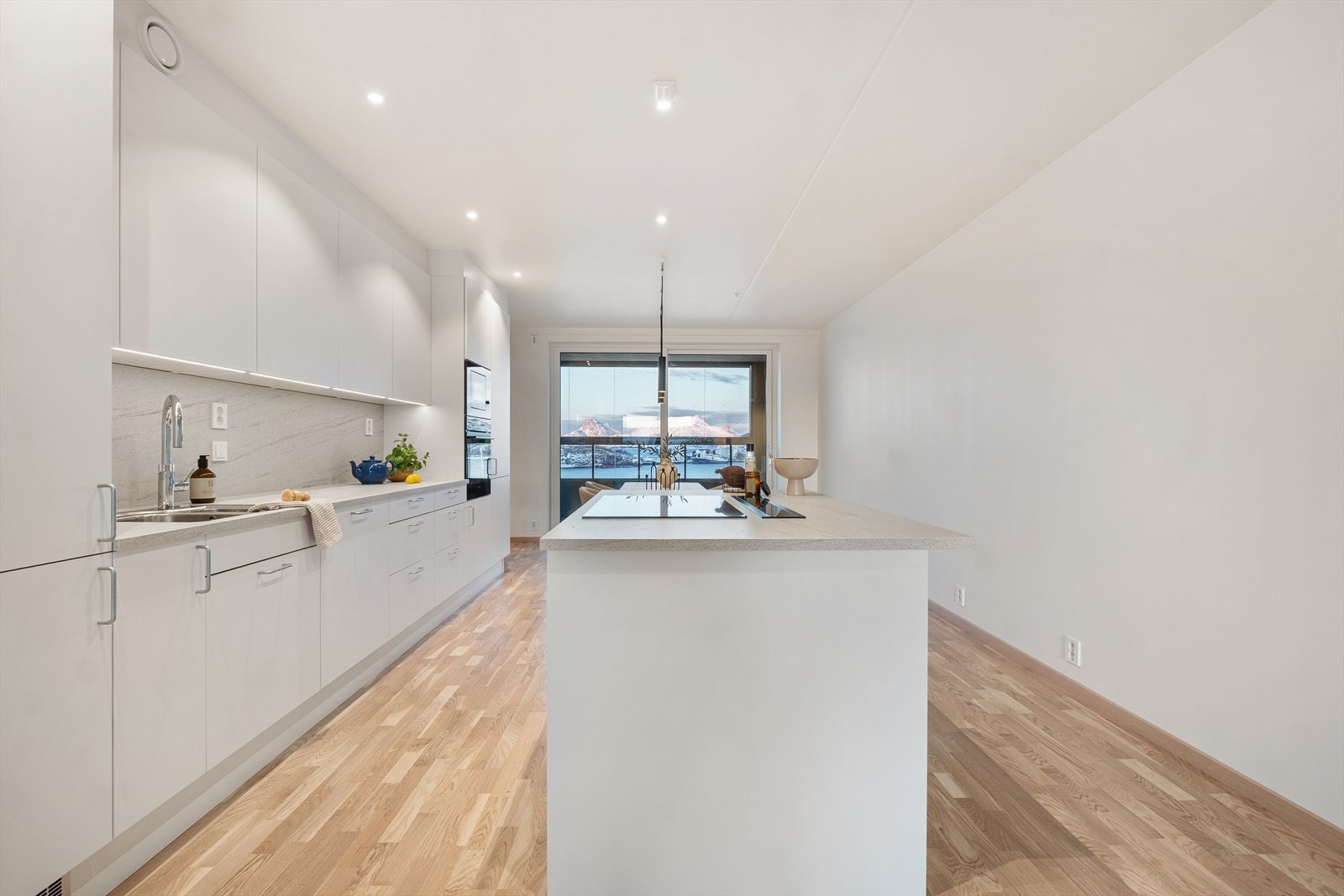 Kjøkkeninnredningen har slette, hvite fronter og rikelig med skap- og benkeplass. Galleribilde