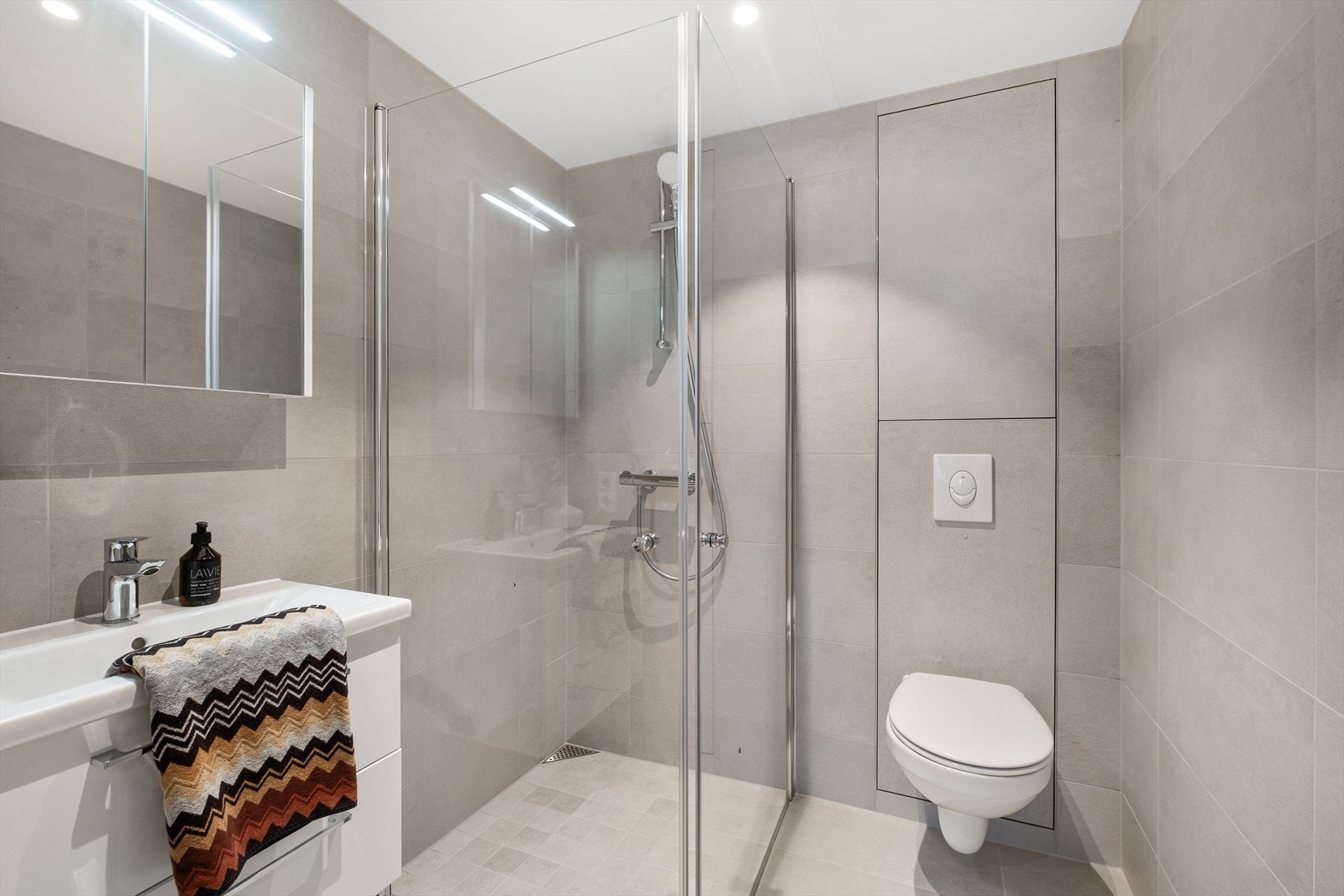 Også her er det dusjhjørne med glassdører, vegghengt toalett og servantinnredning. Galleribilde