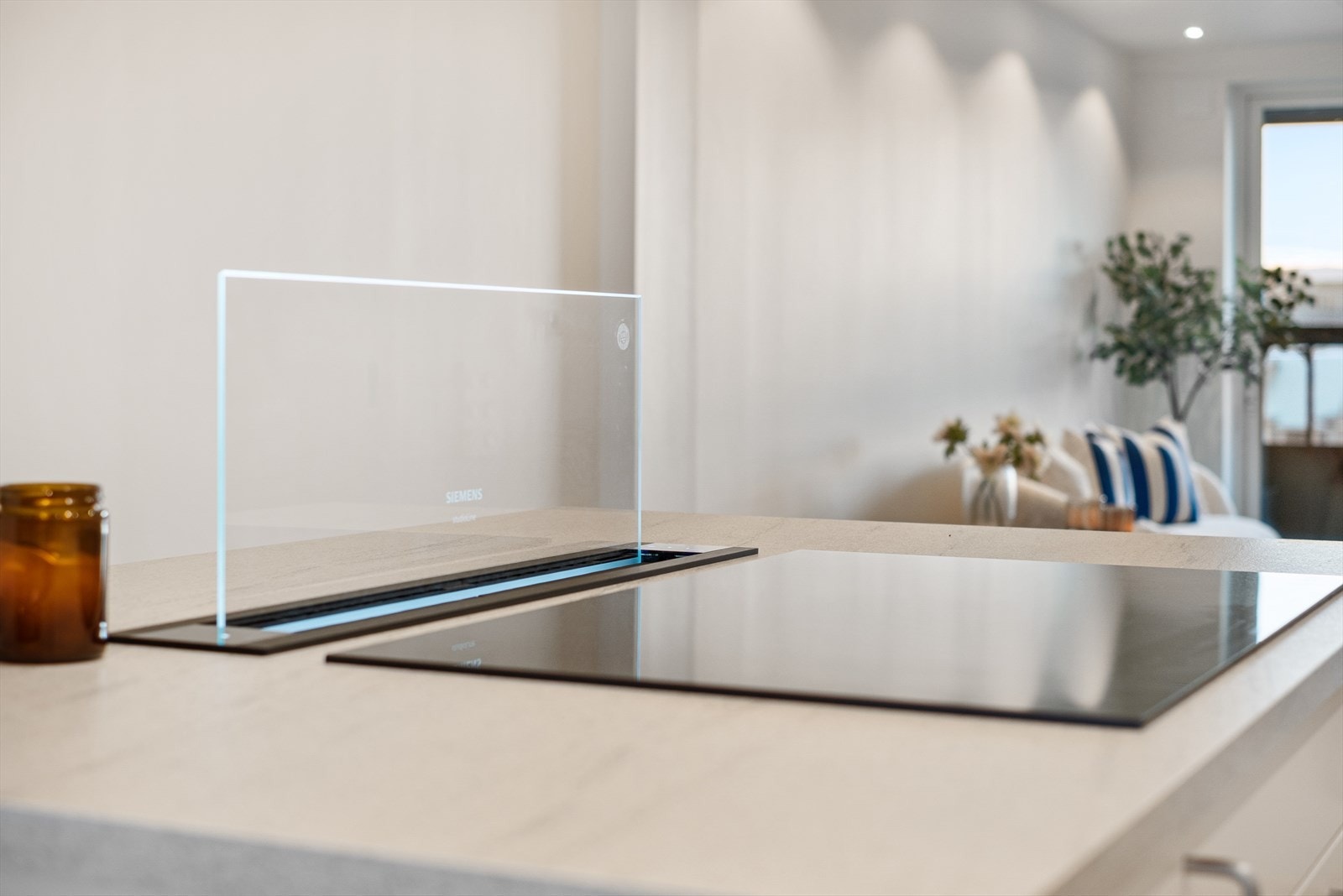 Her finner du en bred platetopp med induksjon og et praktisk, nedfelt avtrekk direkte i benkeplaten. Galleribilde