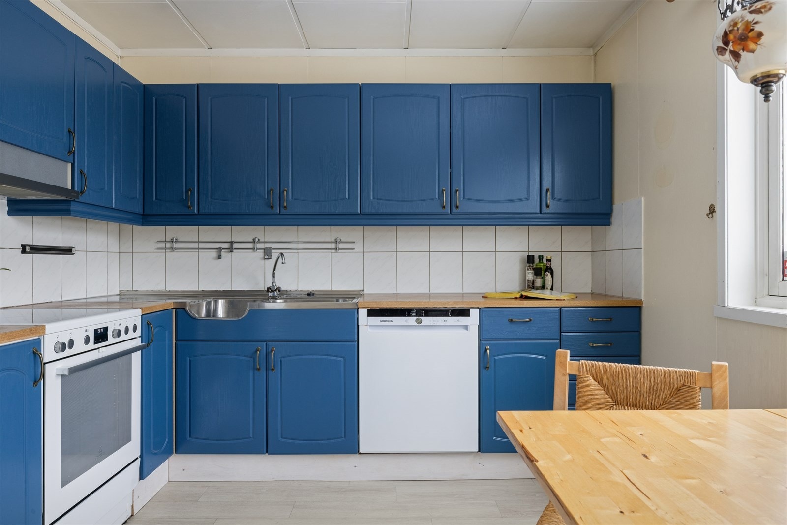 Kjøkkenet er utstyrt med frittstående komfyr, oppvaskmaskin og kjøl-/fryseskap. Komfyr og oppvaskmaskin medfølger salget. Galleribilde