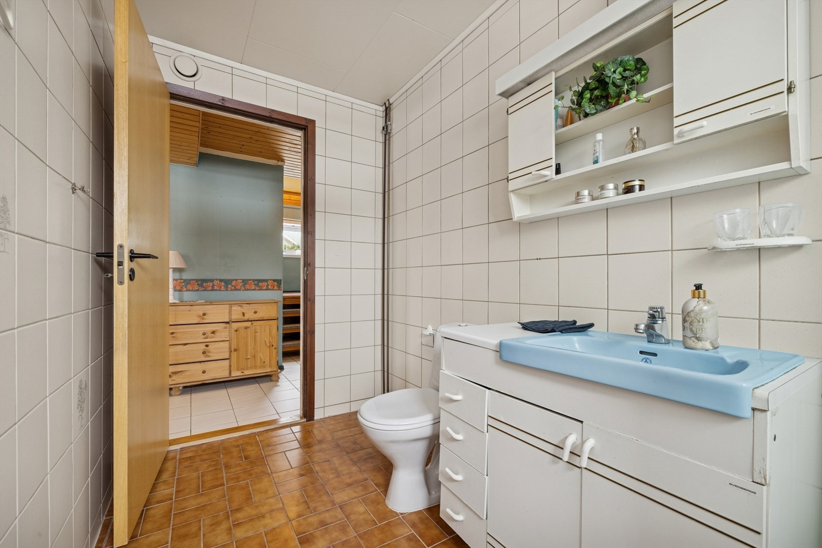 Rommet er innredet med servantinnredning med skuffer og skap, samt overskap. Galleribilde