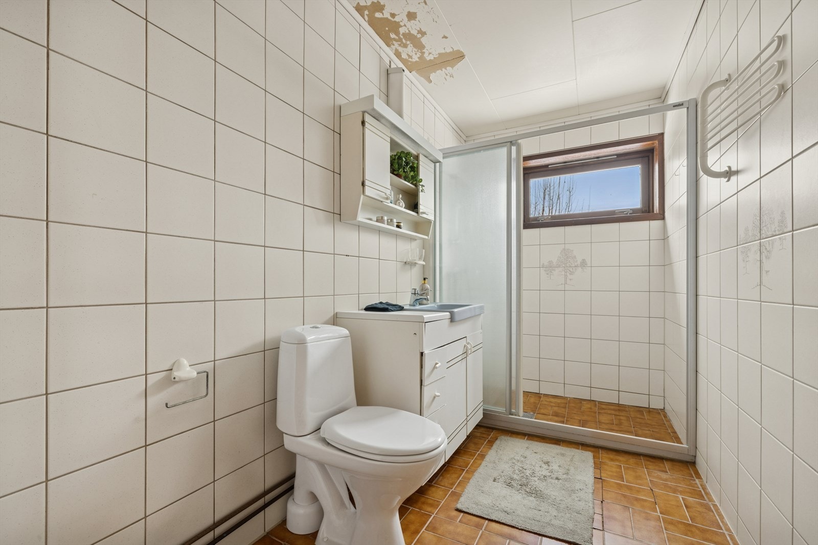 Badet i første etasje har flislagte overflater, varmekabler i gulvet og dusjavlukke med skyvedør. Galleribilde