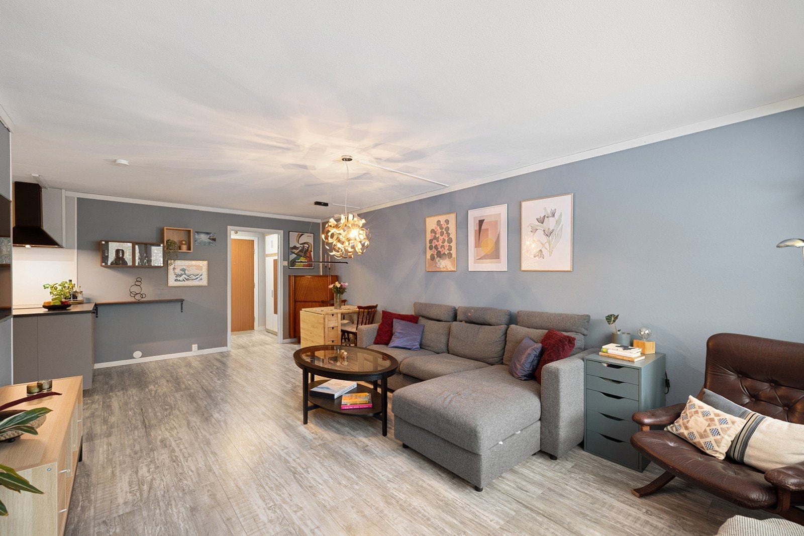 Stuen er lys med åpen løsning mot kjøkken, som skaper en luftig og sosial atmosfære. Galleribilde