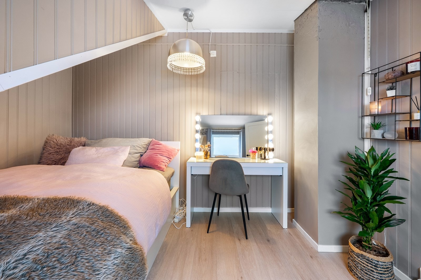 Plass til dobbeltseng og skrivebord i rommet med panelvegger og laminatgulv. Galleribilde