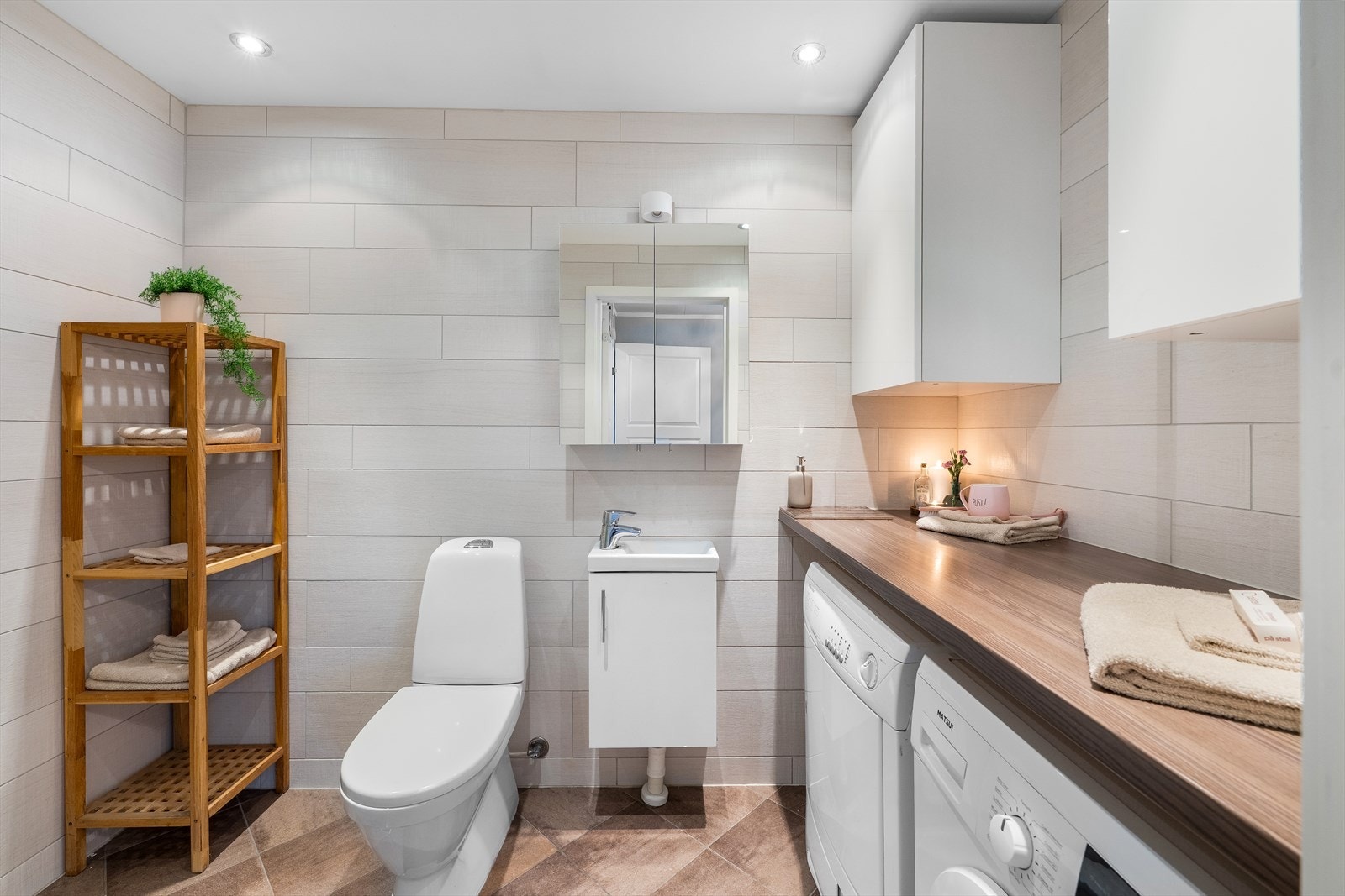 Flislagte vegger og gulv med varmekabler. Praktisk arbeidsbenk og opplegg til vaskemaskin. Galleribilde