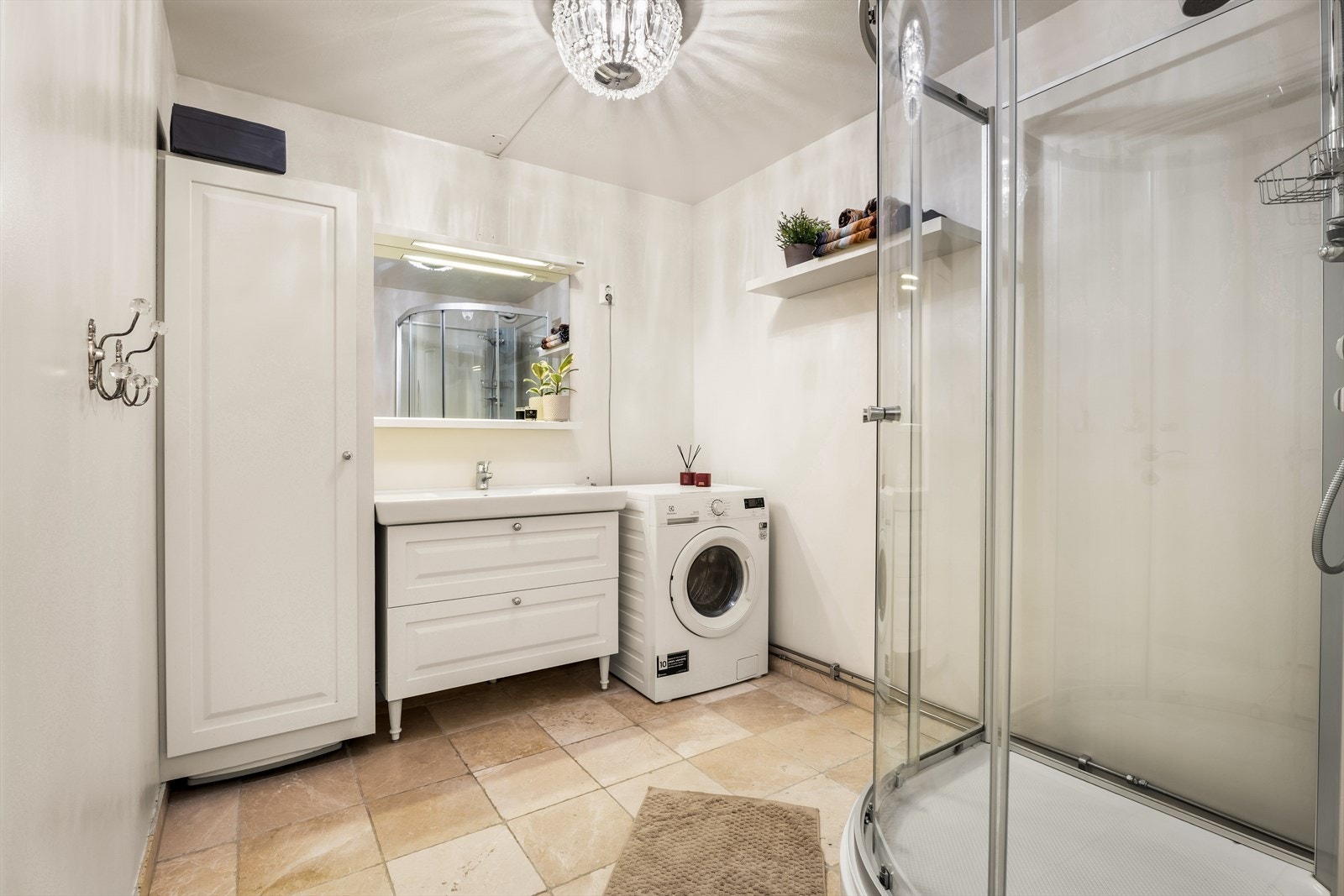 Badet har fliser på gulvet med elektriske varmekabler, malte plater på veggene og malt betong i taket. Rommet er innredet med en servantinnredning, vegghengt toalett, dusjkabinett, oppbevaringsskap samt opplegg for vaskemaskin. Galleribilde