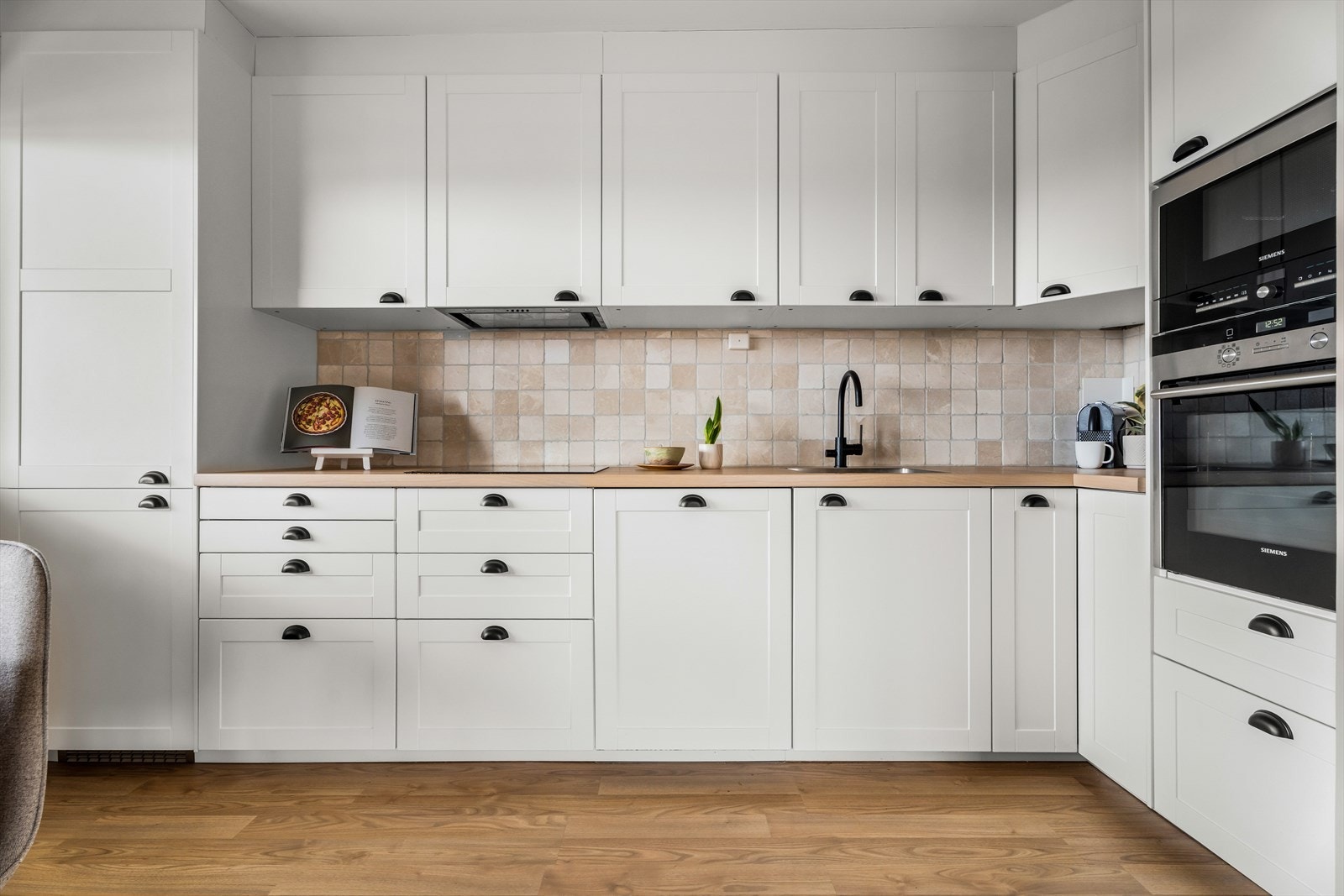 Kjøkkenet er utstyrt med fliser mellom benk og overskap for enkel rengjøring. Galleribilde