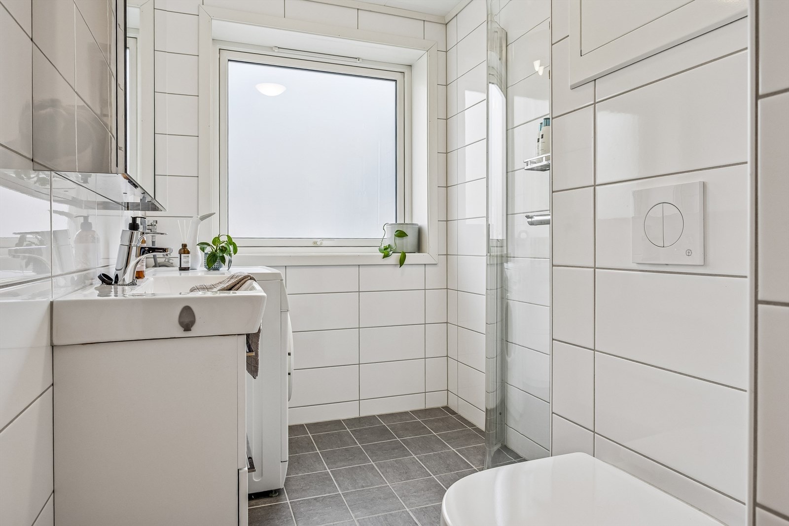 Her er det varmekabler i gulvet for komfort, dusjdører i klart glass og opplegg for vaskemaskin. Vaskemaskinen følger handelen. Galleribilde