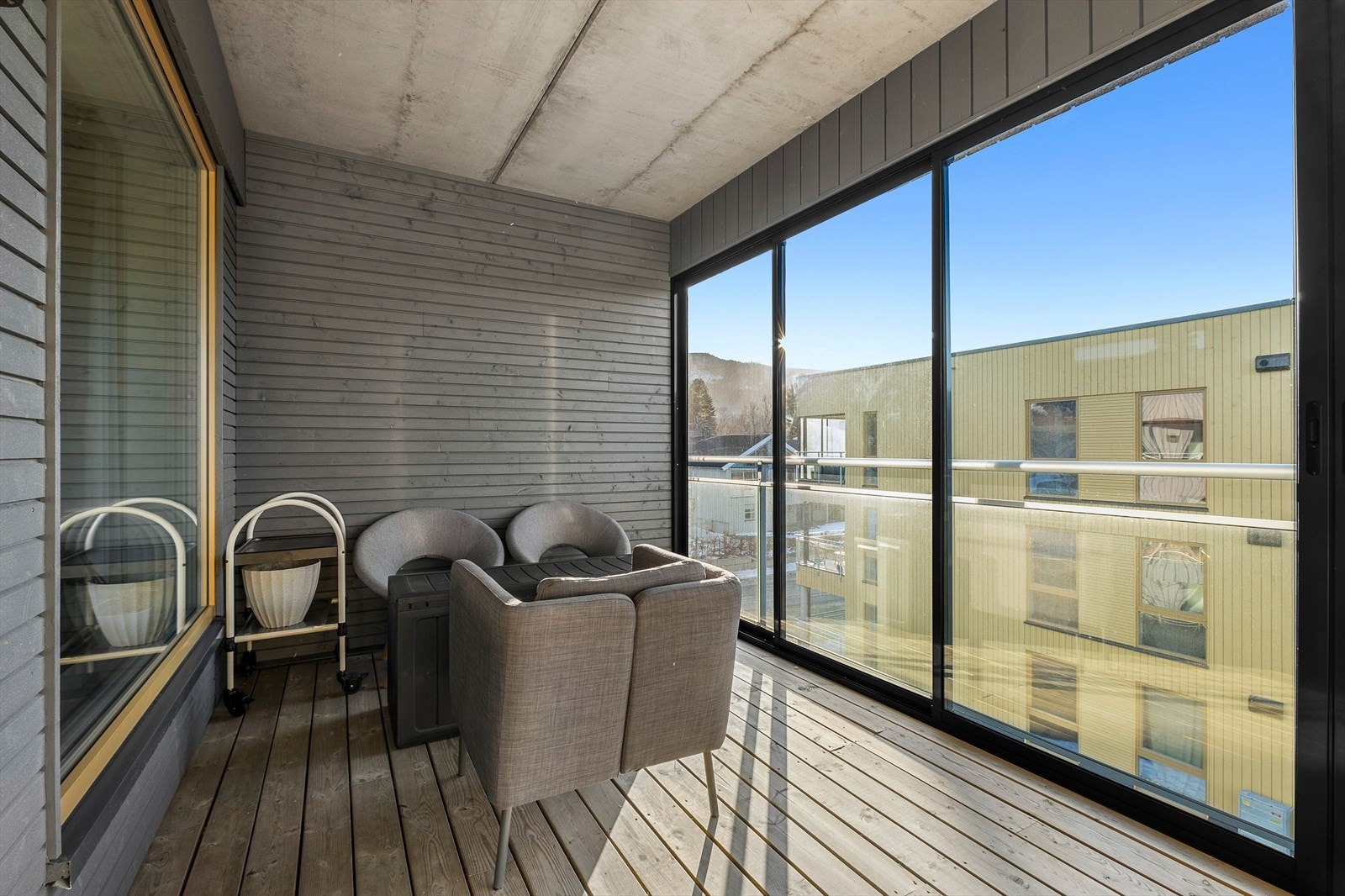 Balkongen er overbygd og lun, så terrassen blir en naturlig forlengelse av stua på fine sommerdager. Galleribilde