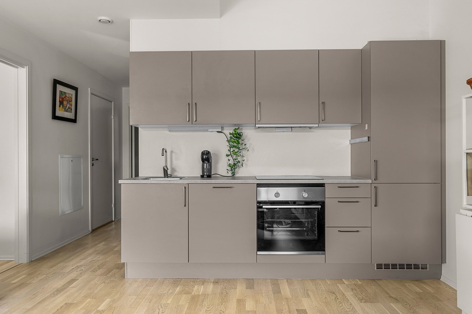 Kjøkkenet byr på integrerte hvitevarer som oppvaskmaskin, kombiskap, platetopp og stekeovn. Disse medfølger handelen. Galleribilde