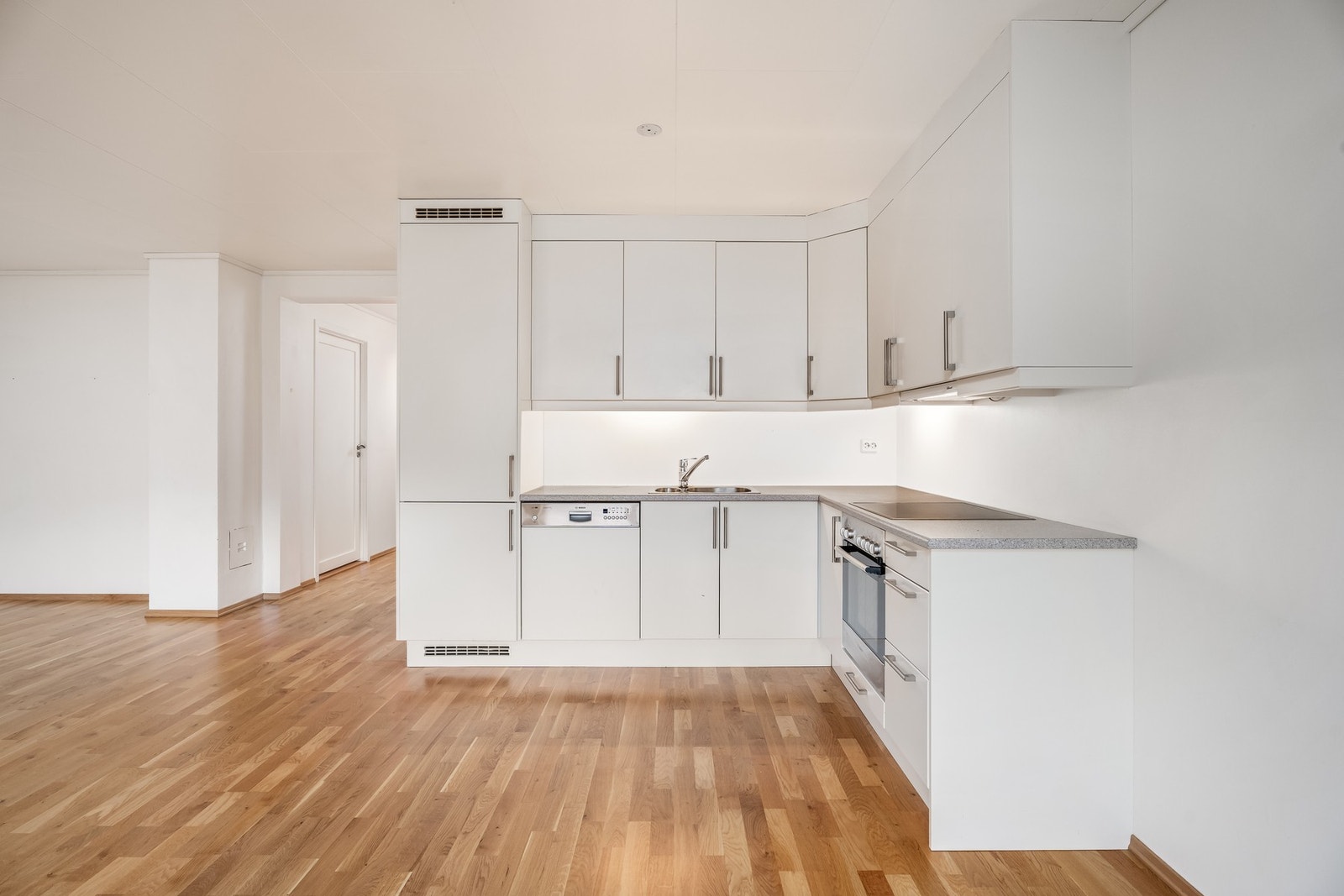 Kjøkken med stilrene, hvite flater. Galleribilde