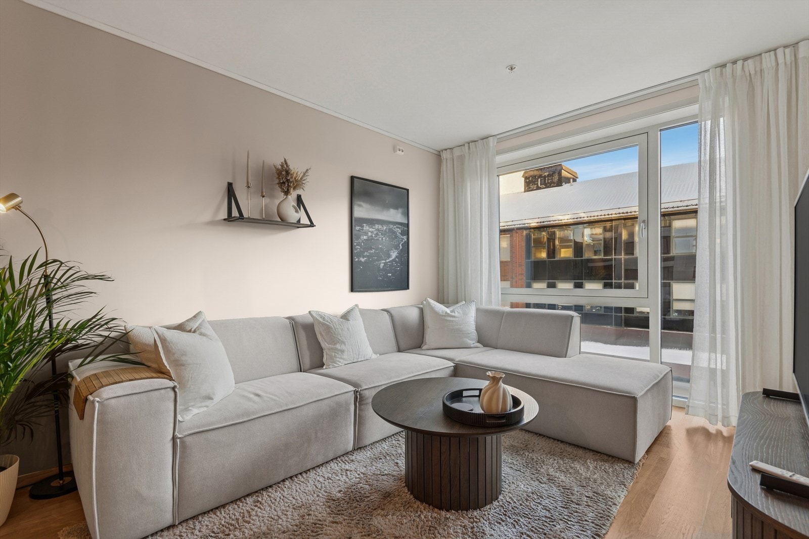 Sofasone med plass til stor sofagruppe og utsikt gjennom store vinduer. Galleribilde