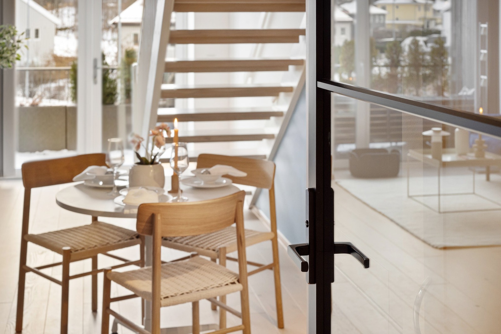 Det er satt inn en moderne glassdør med sorte karmer mellom oppholdsrom og gang Galleribilde