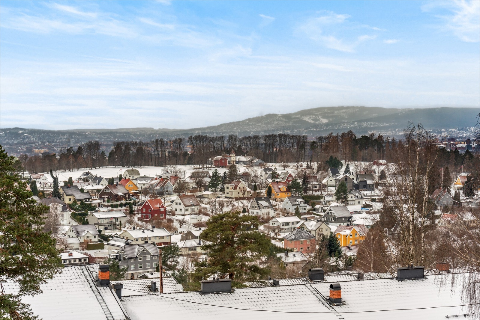 Flott utsikt ned mot Nordre Skøyen hovedgård og mot Holmenkollen i bakgrunnen. Galleribilde