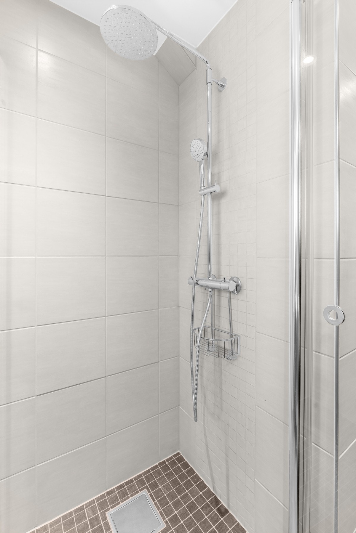 Rommet er ellers utstyrt med et romslig dusjhjørne med med to skyvbare foldedører av glass, og det er ellers opplegg for vaskemaskin på badet. Galleribilde