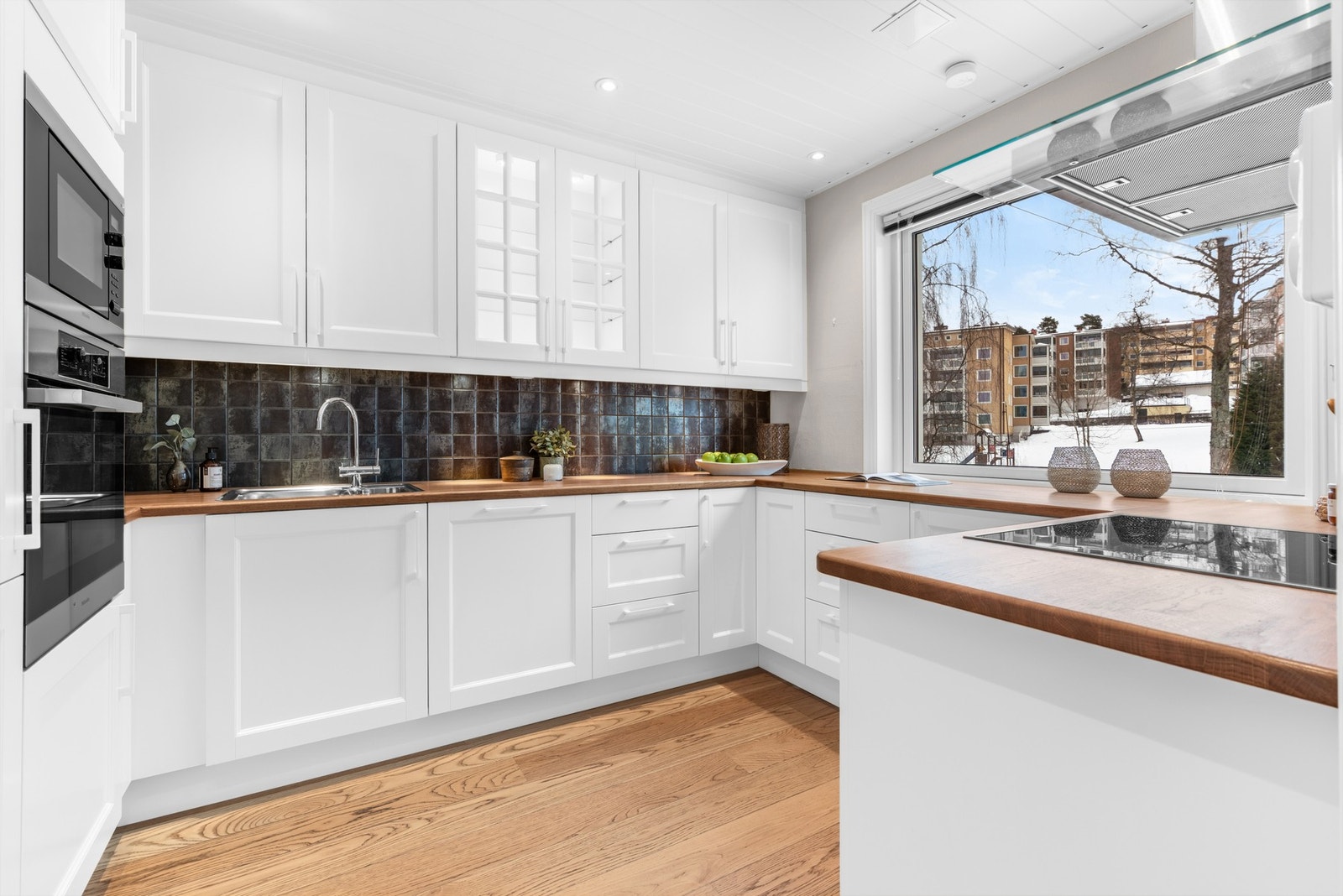 Pent kjøkkenet fra 2013 som ligger i eget rom med adkomst fra stuen. Innredningen har profilerte fronter, dempefunksjoner og benkeplater av heltre eik. Galleribilde