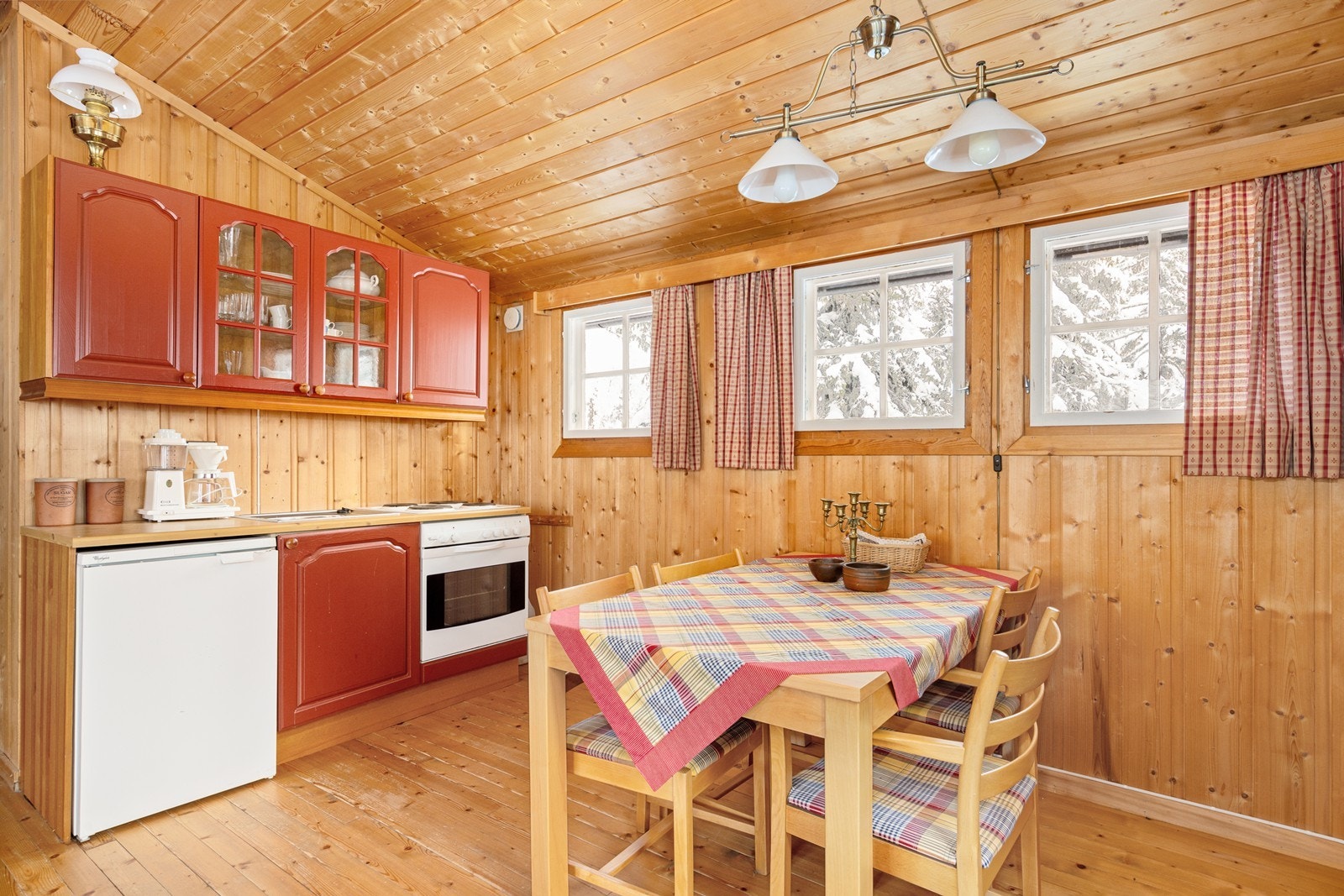 Kjøkkenet har en behandlet innredning med profilerte fronter, frittstående komfyr og kjøleskap, og rommet er ventilert med en veggventil. Galleribilde