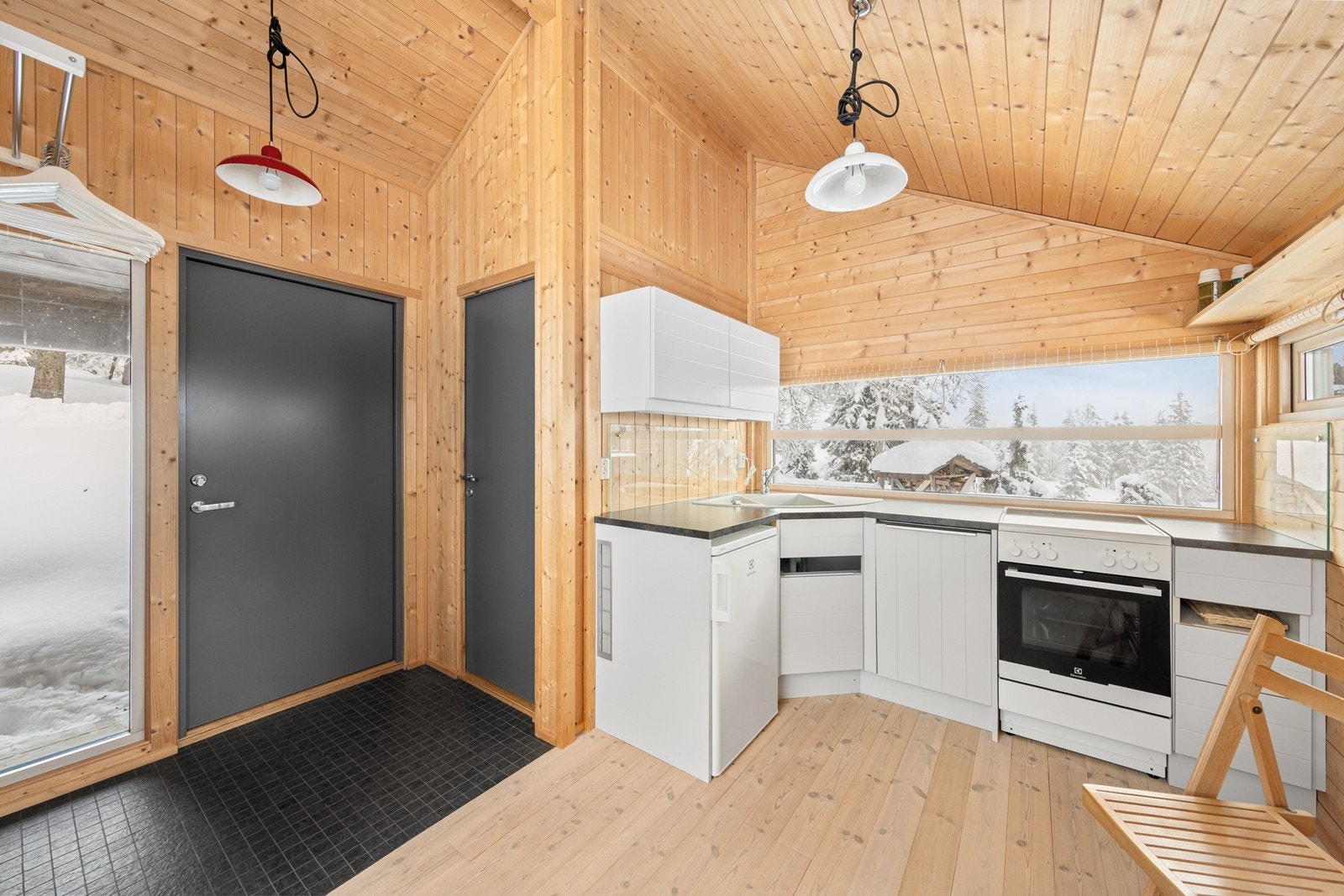 Kjøkkenet er utstyrt med en behandlet innredning med lyse, profilerte fronter, opplegg for komfyr og kjøleskap samt integrert oppvaskmaskin. Galleribilde