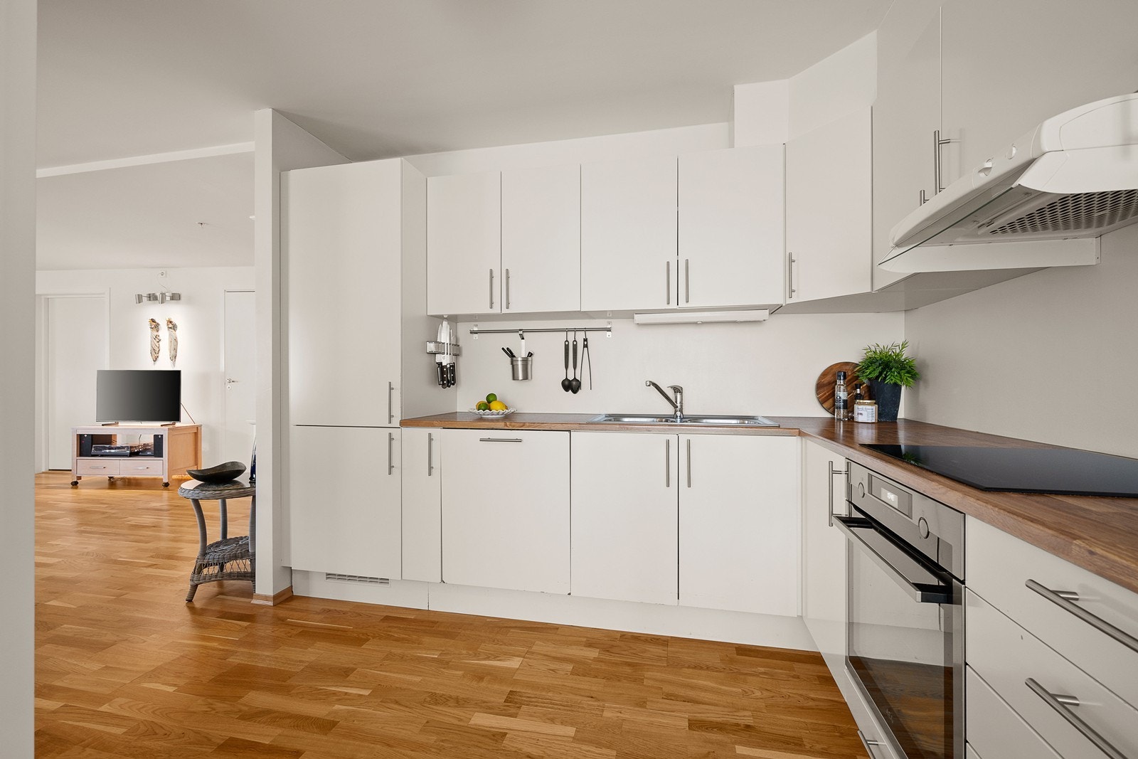 Lys kjøkkeninnredning med integrerte hvitevarer Galleribilde