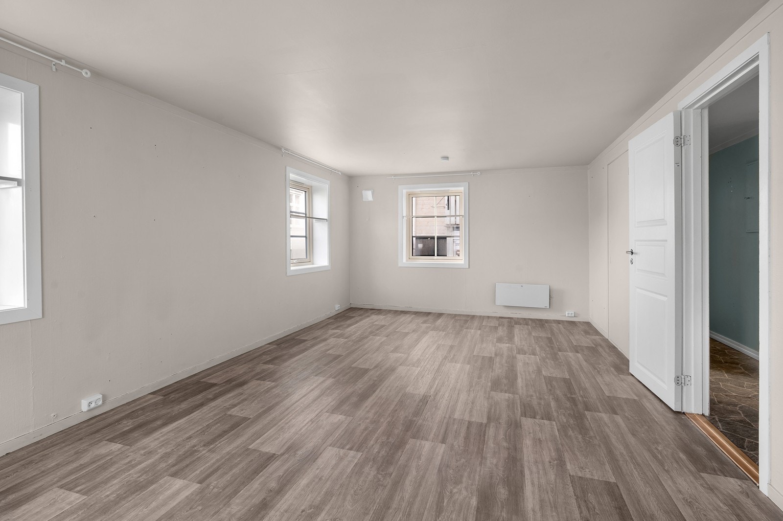 Romslig stue med god plass til flere møbelgrupper Galleribilde