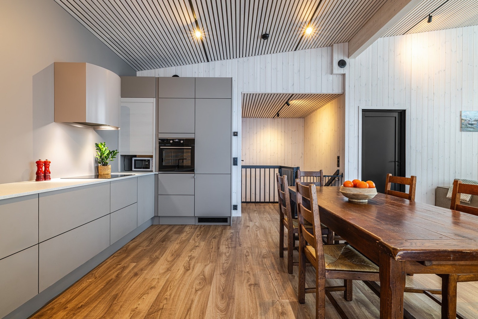 Det stilrene kjøkkenet er sømløst integrert med stuen og danner boligens naturlige samlingspunkt. Galleribilde