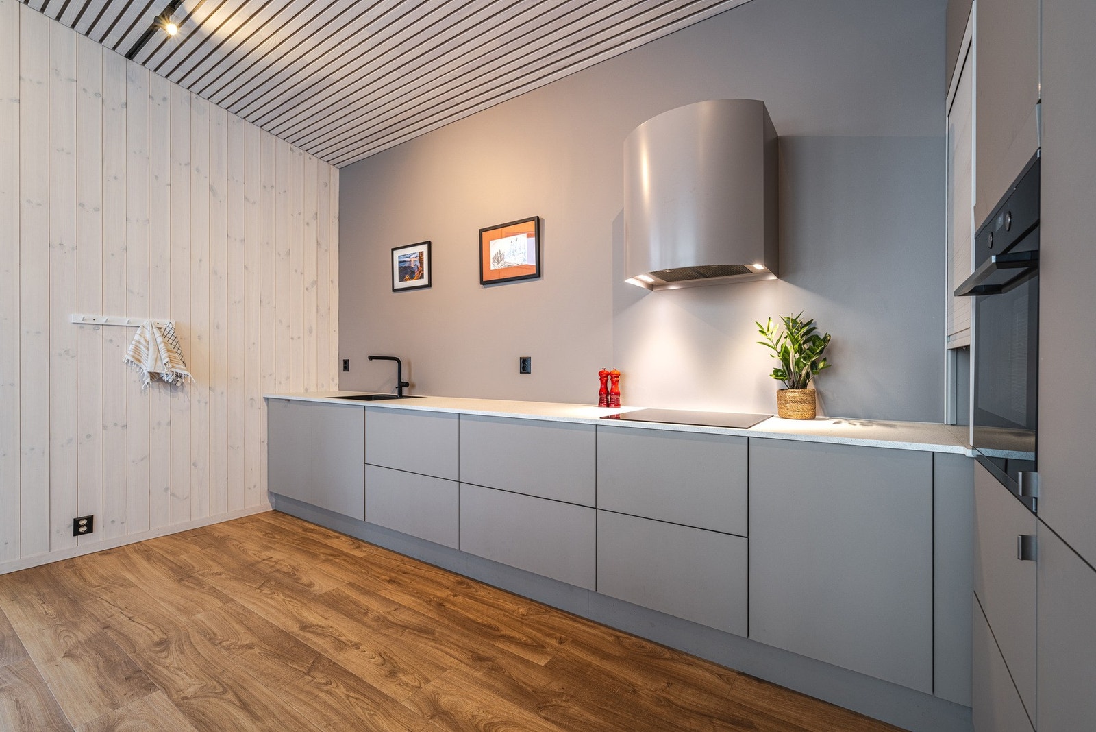 Kjøkkenet er lyst, moderne og innbydende med gjennomtenkte løsninger, rene linjer og integrerte hvitevarer. Galleribilde