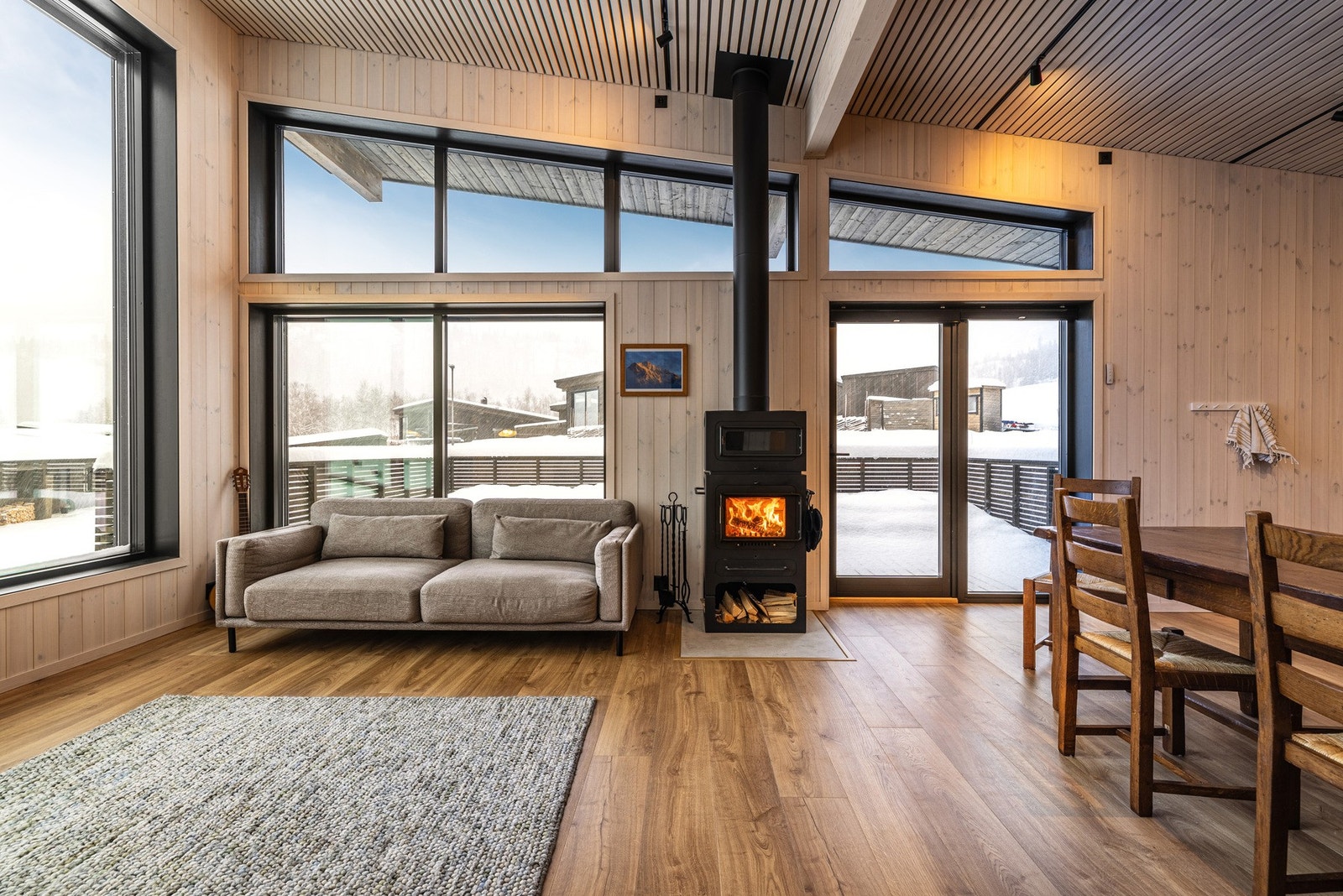 Stilrene detaljer og tidløse materialvalg kombinert med store vinduslater og en lun og hyggelig peisovn. Galleribilde