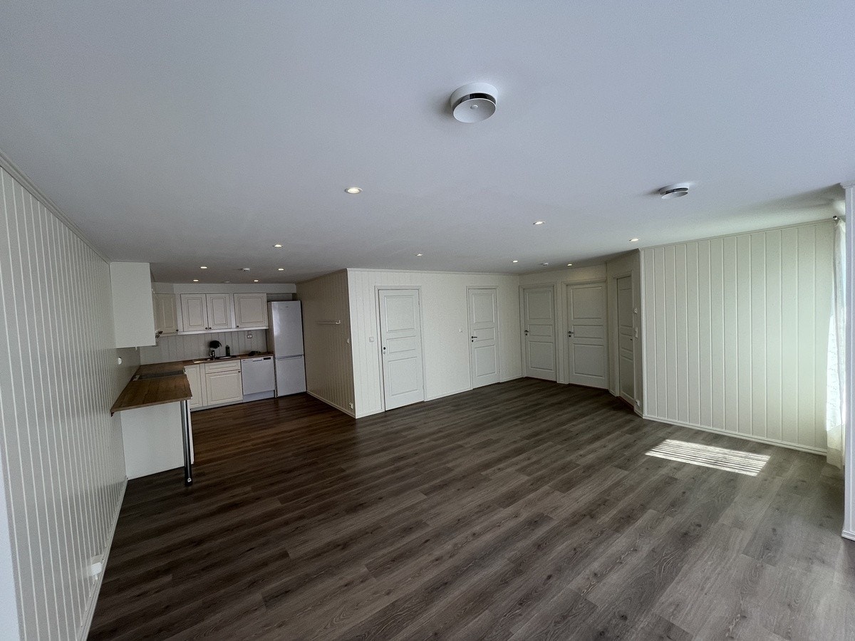 Romslig og åpen stue-/kjøkkenløsning med godt lysinnslipp fra store vinduer. Perfekt for sosiale soner. Galleribilde