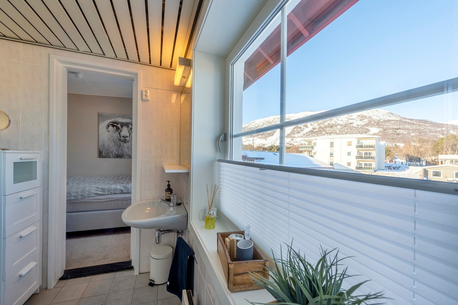 Badet er blant annet innredet med: gulvmontert toalett, veggmontert servant på underskap, speil og hylle. Galleribilde