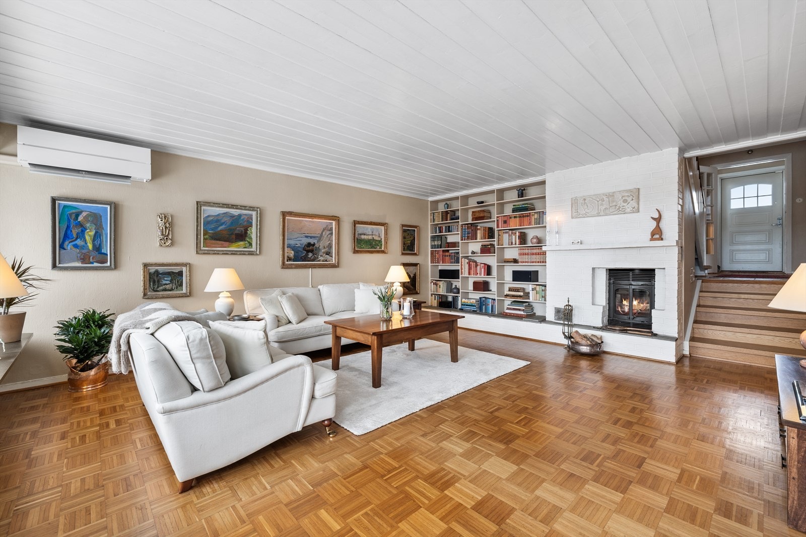 Romslig stue med god plass til sofagruppe - peisen blir et naturlig blikkfang Galleribilde