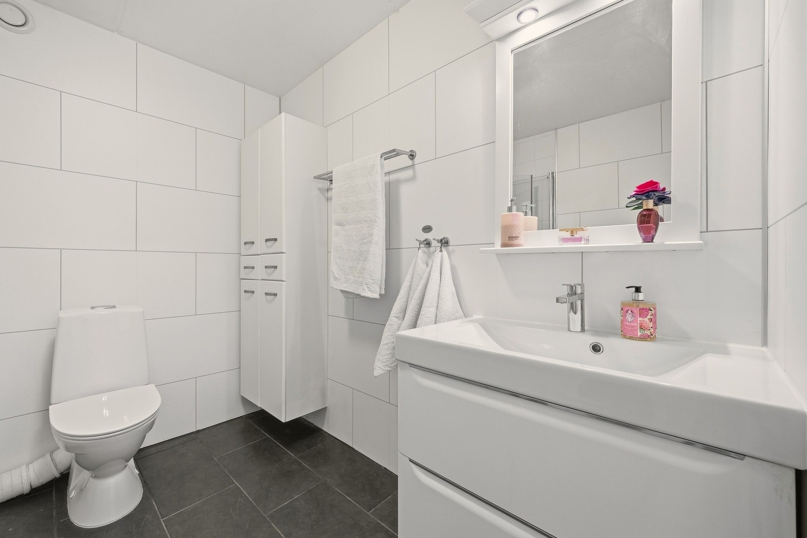 Praktisk veggmontert servantskap med skuffer, speil og overlys. Galleribilde