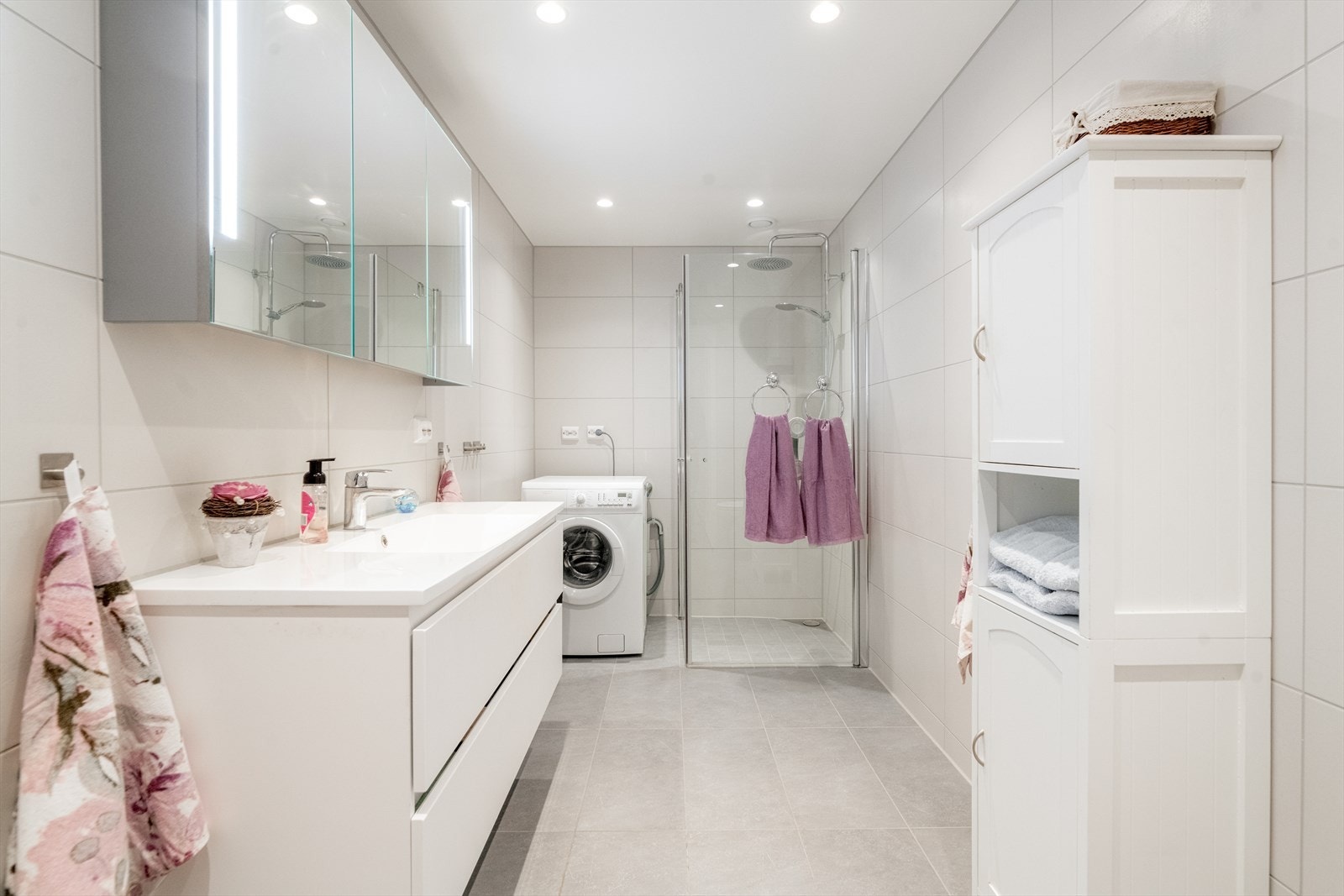 Lyst, flislagt bad av god størrelse med pen og bred servantinnredning. Heldekkende servantplate og praktisk speilskap med integrert belysning. Galleribilde