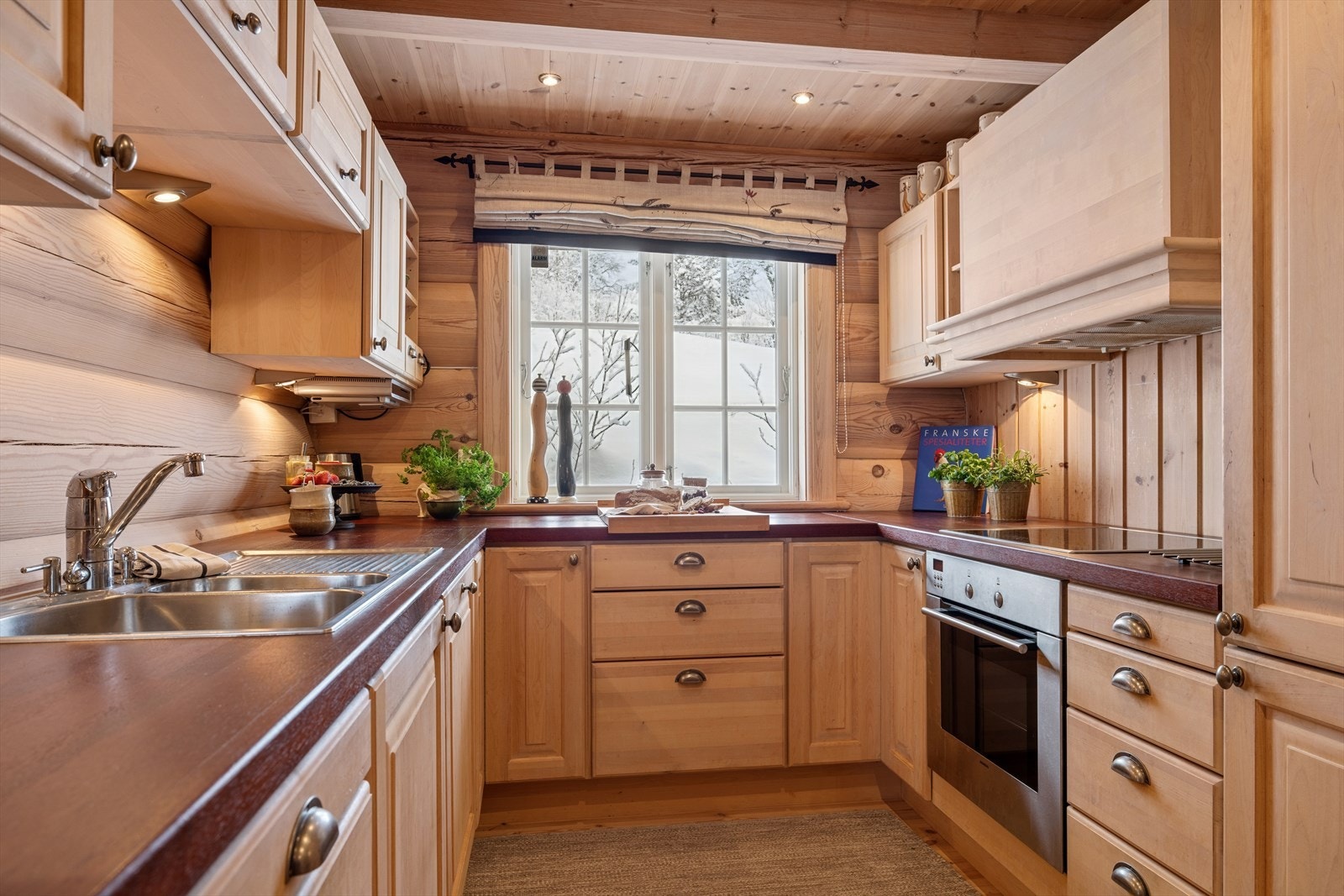 Kjøkkenet byr på heltre fronter og benkeplater som gir en solid og tradisjonsrik hyttesjarm. Galleribilde
