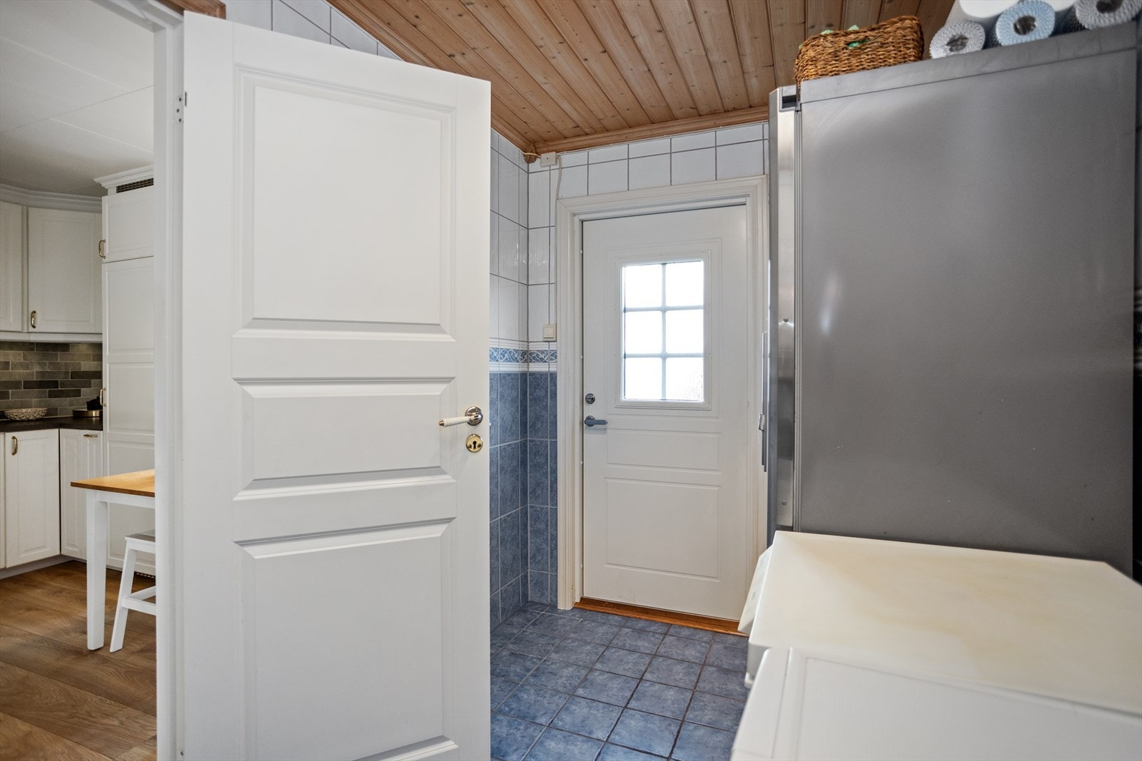 Vaskerommet har inngang fra kjøkkenet og kan hvis ønskelig også kombineres som et praktisk grovkjøkken til hjemmet. Den utskiftende utgangsdøren gir lettvint adkomst til hagen på nordsiden av huset. Galleribilde