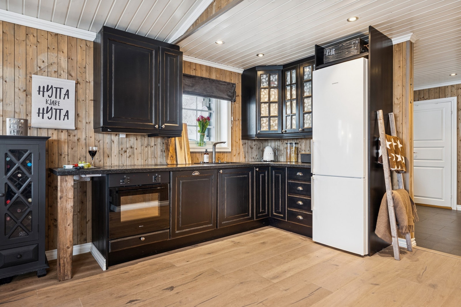 Kjøkkenet har innredning fra byggeår med integrerte hvitevarer og gode arbeidsflater. Galleribilde