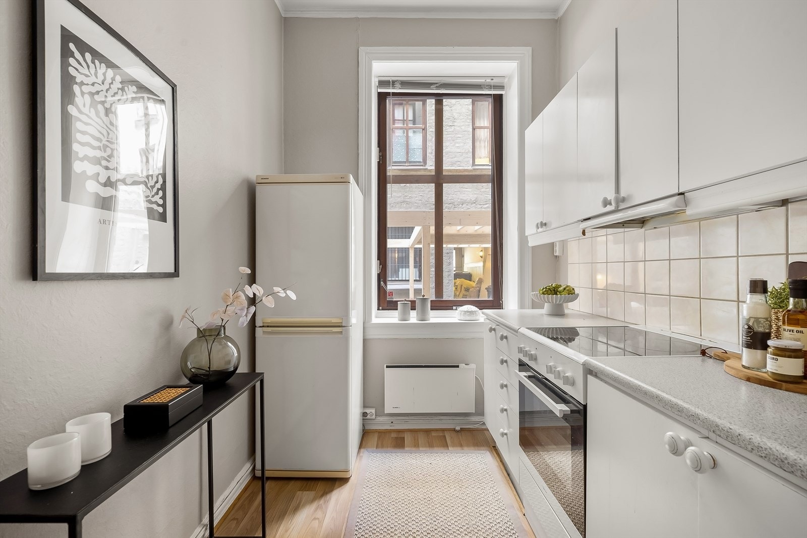 Separat kjøkken med kjøkkeninnredning med slette fronter, fliser på vegg over kjøkkenbenken og benkeplate i laminat. Galleribilde