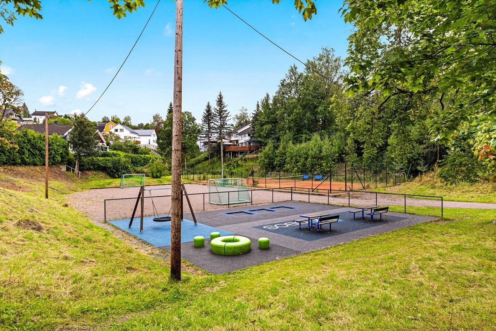 Kun to minutters gange fra boligen finner du en hyggelig aktivitetspark med fotballbane, husker, trampoliner, tennisbane og sitteplasser! Galleribilde