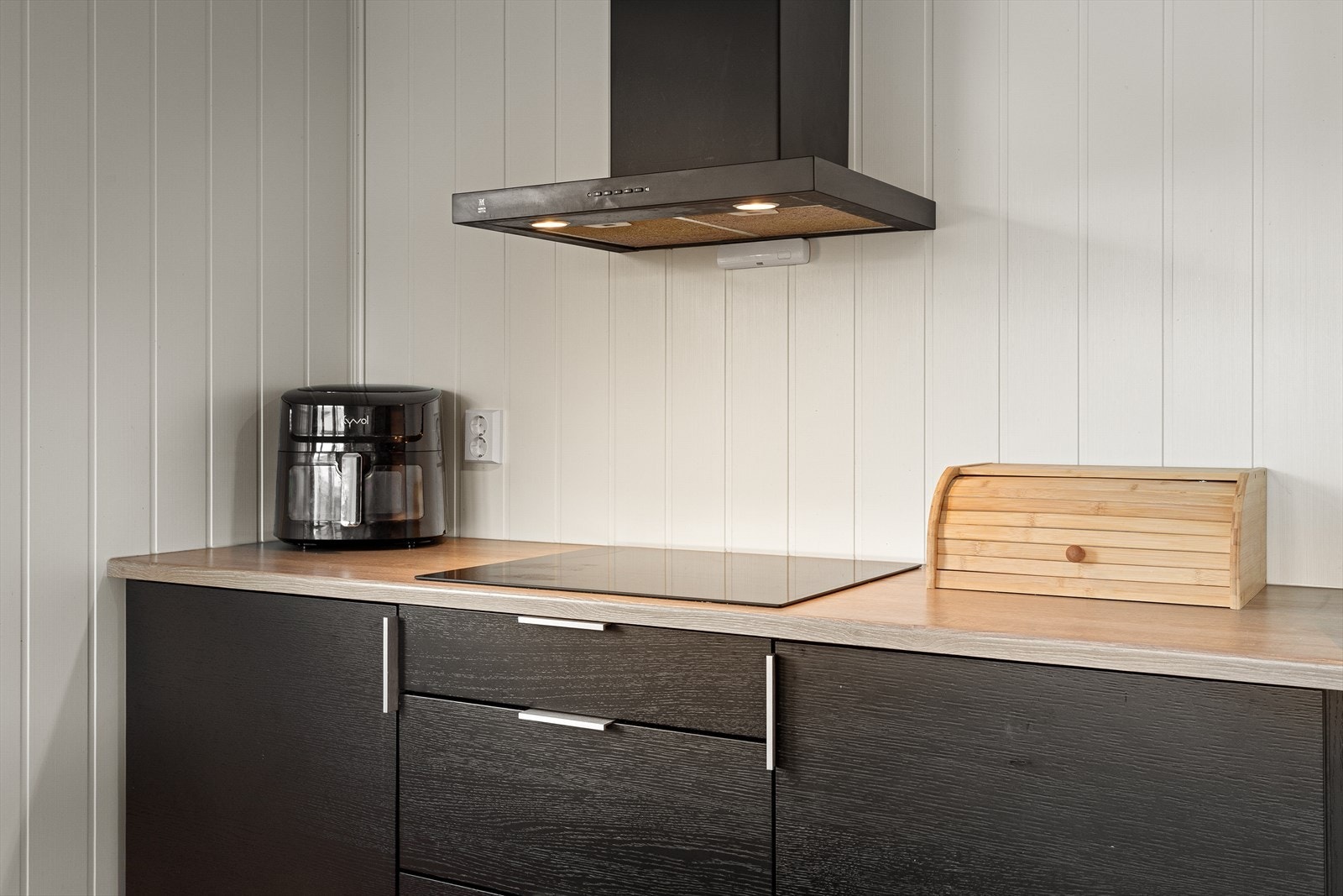 Her er det glatte fronter og benkeplate av laminat. Av kvitevarar er det kjøl/fryseskap, oppvaskmaskin, platetopp og steikeovn Galleribilde