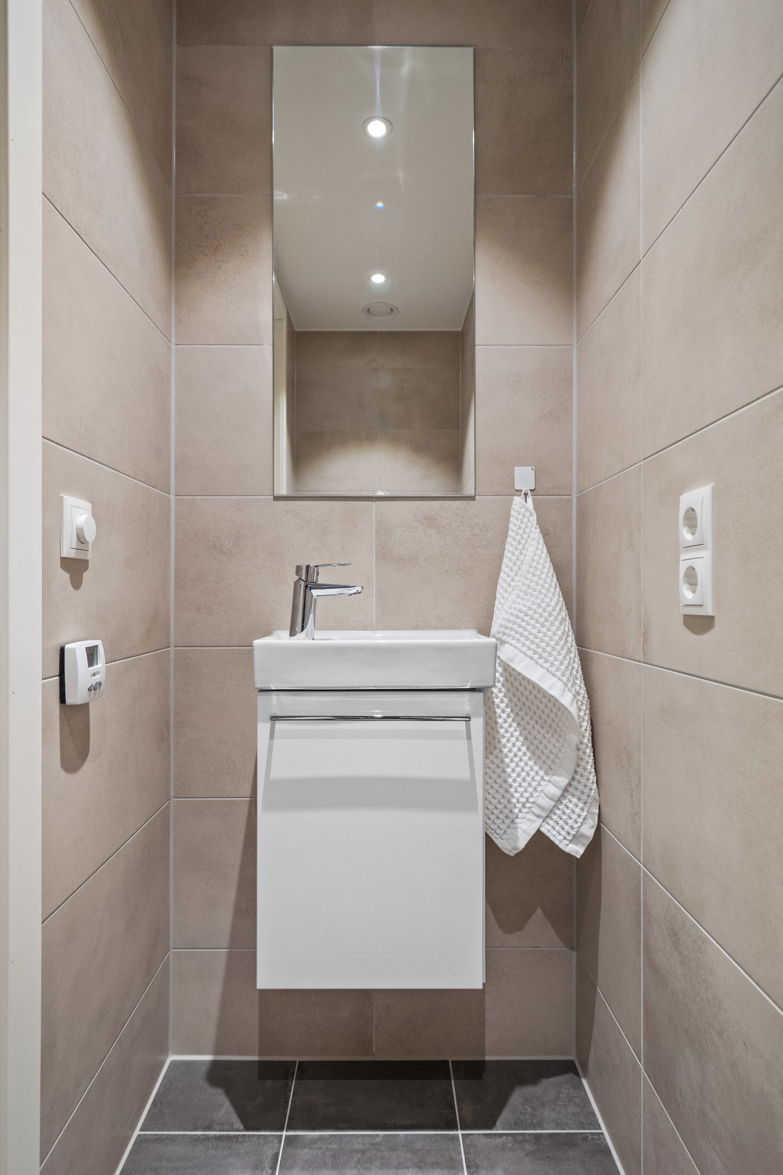 Toalettrom i entré med vegghengt servantinnredning og toalett Galleribilde